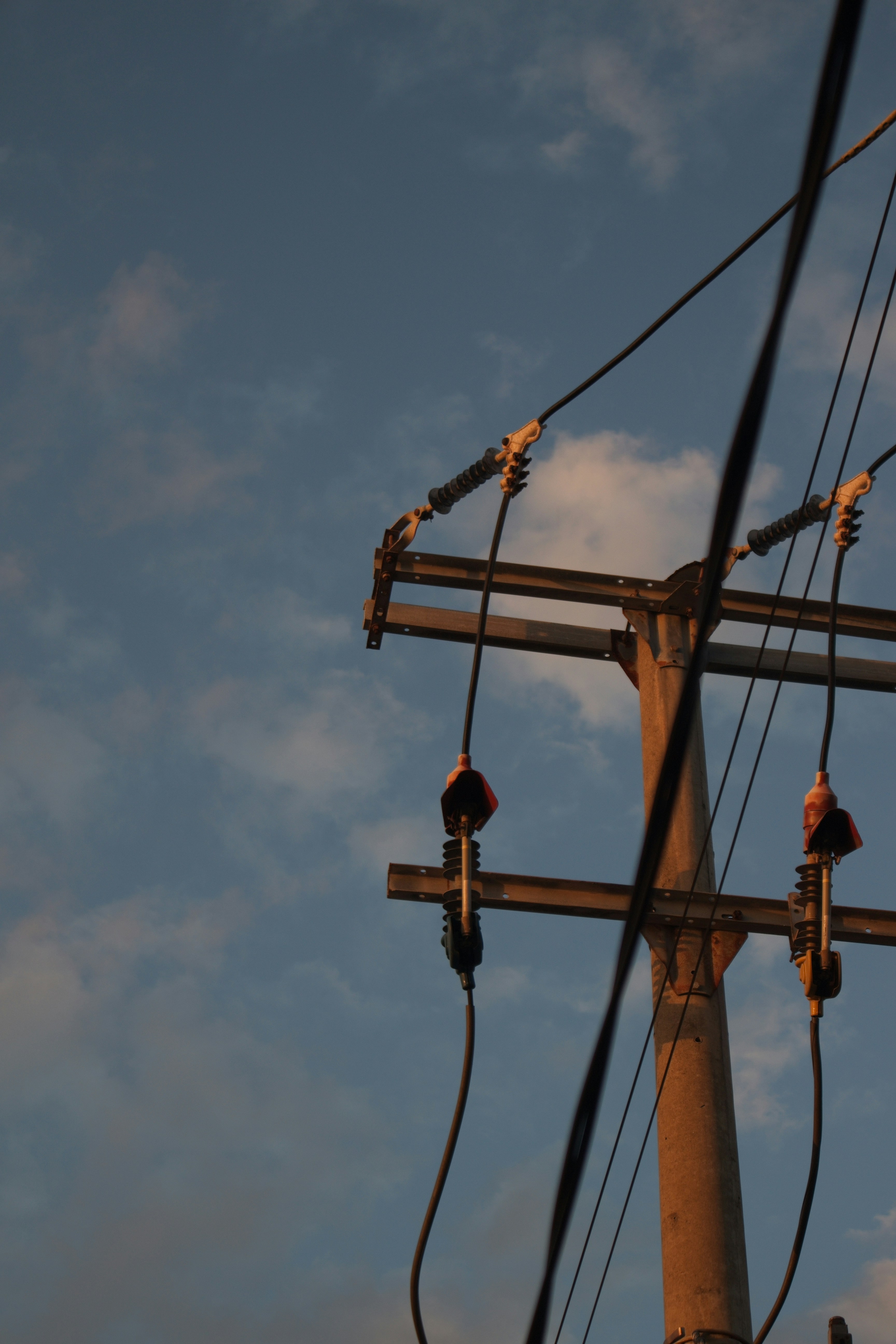 A utility pole with power lines against a cloudy sky