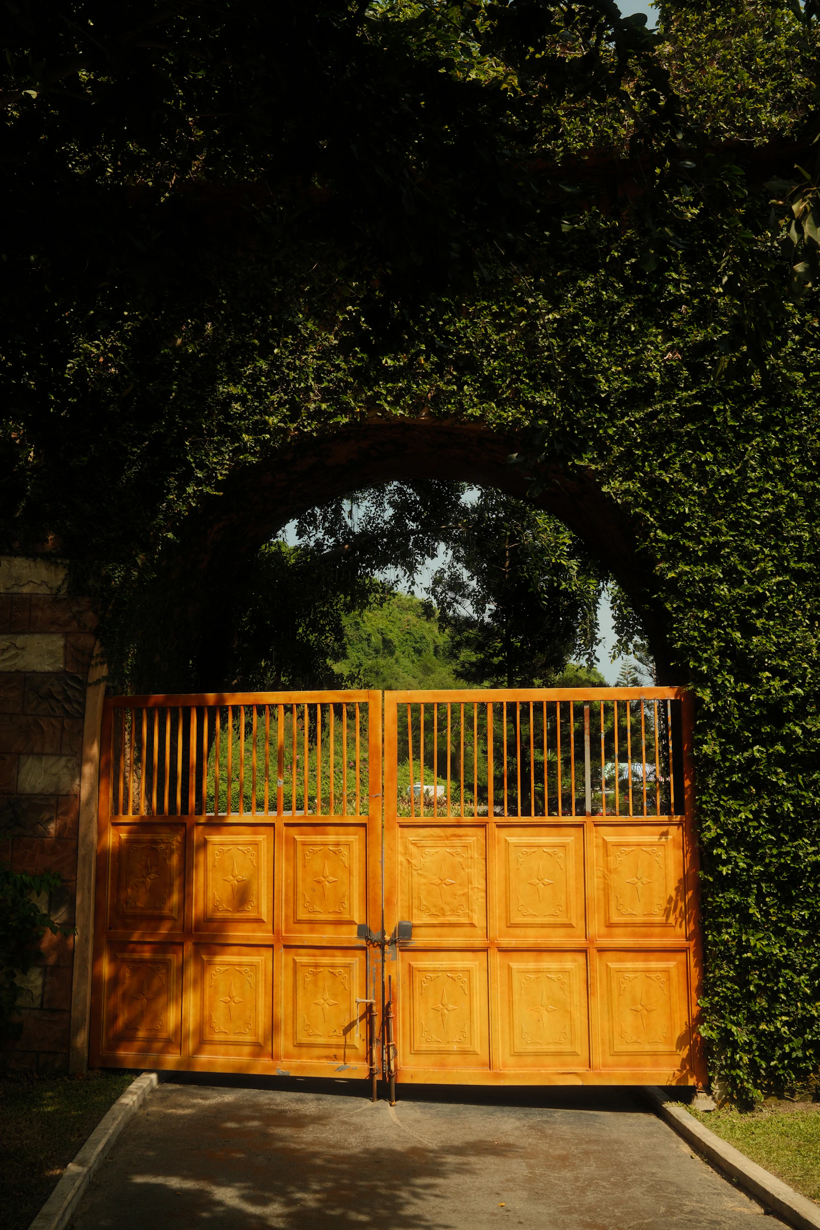 Metal entrance gate framed by landscaping