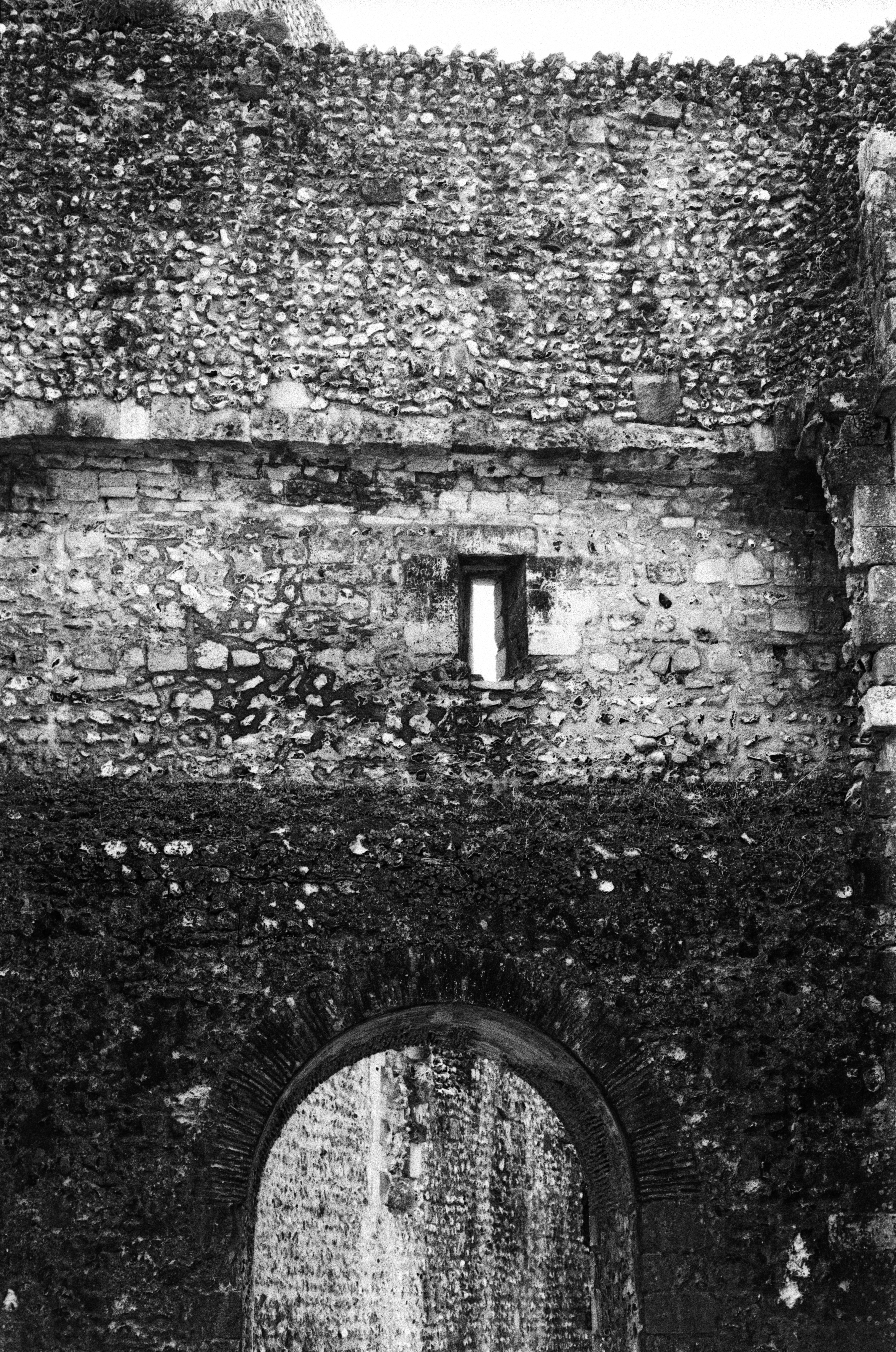 Antica muraglia in pietra con ingresso ad arco e finestra