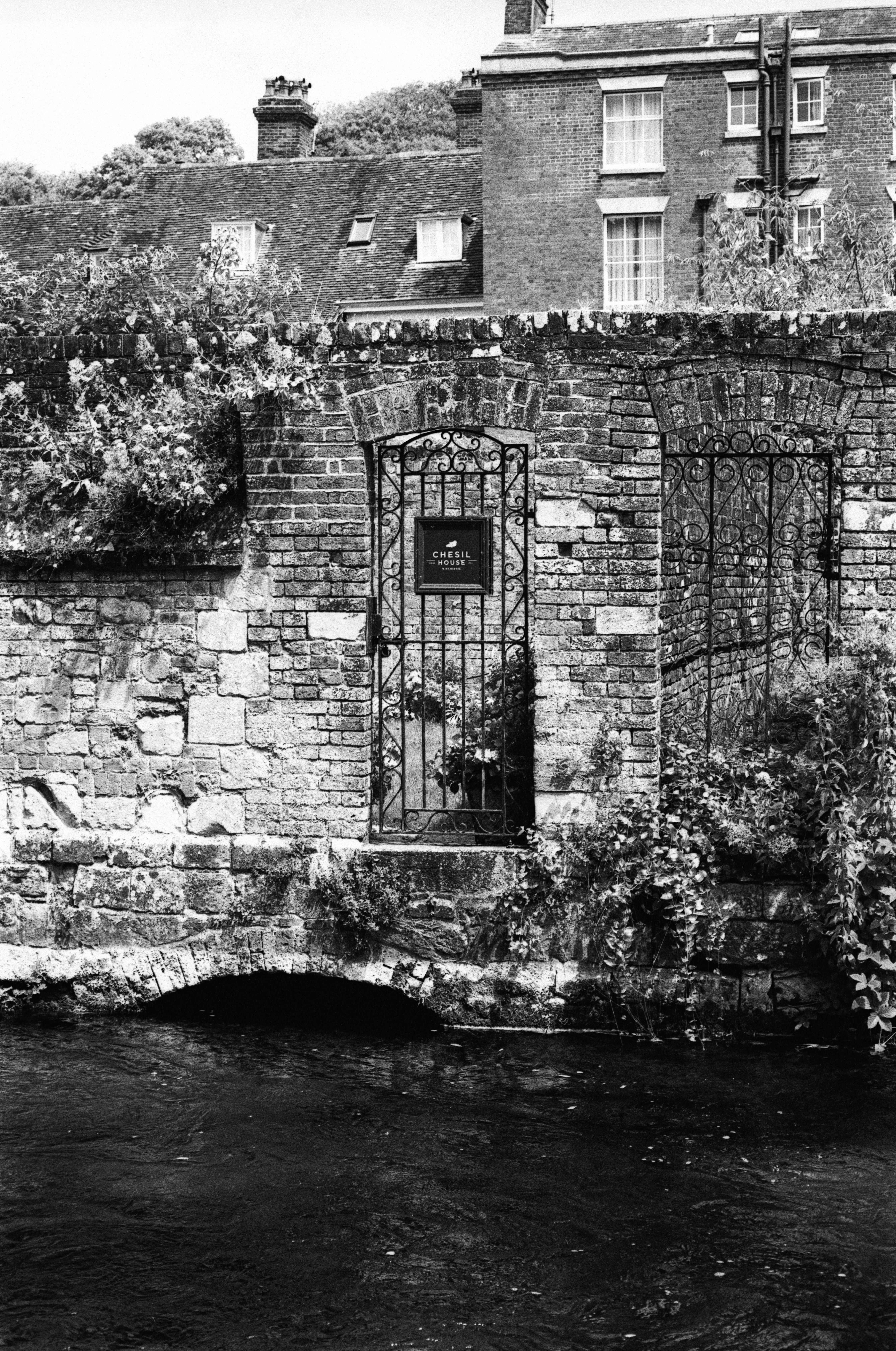 Cancello ornato in muro di mattoni sopra il ruscello del mulino di Winchester