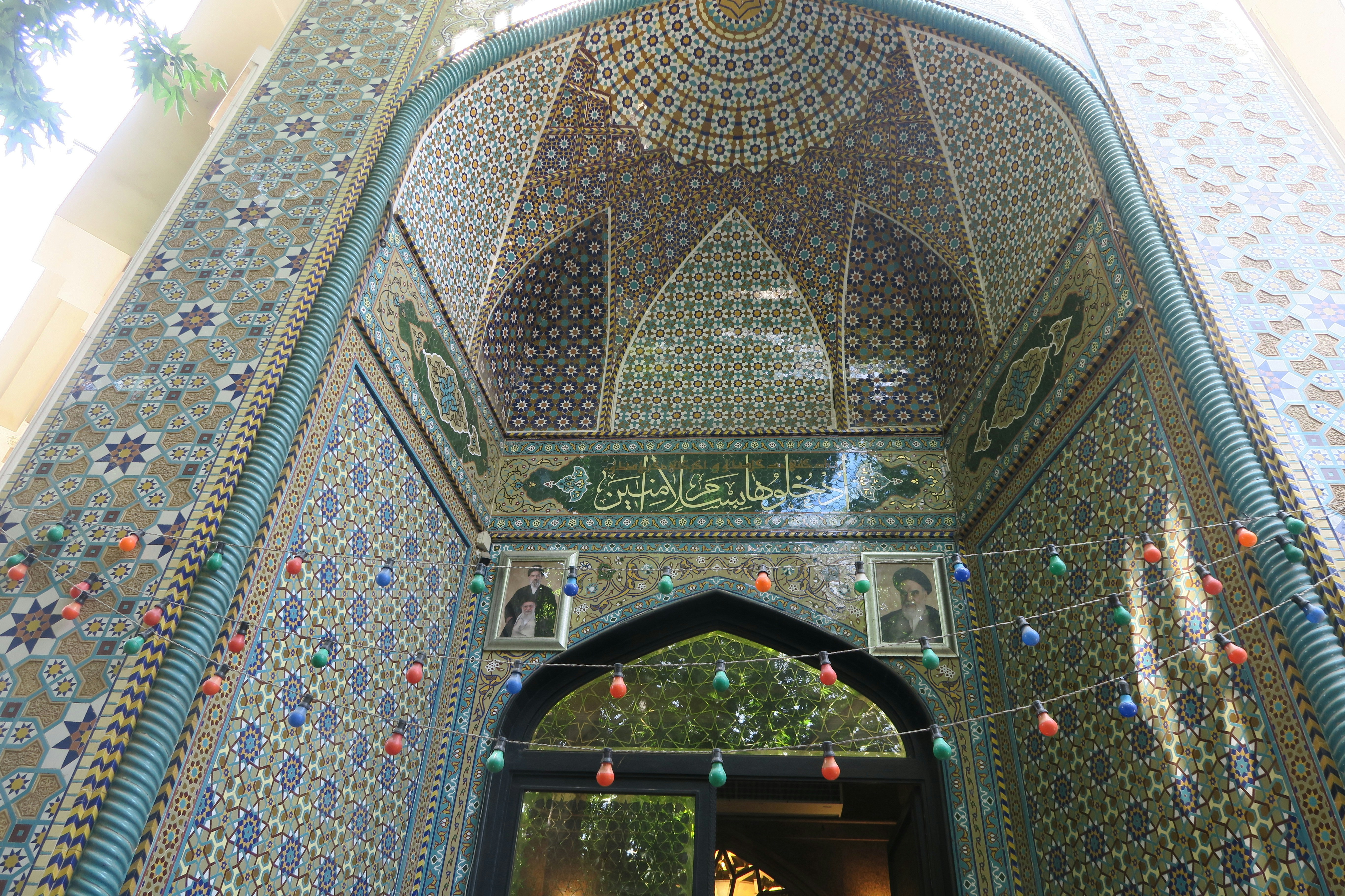 Ornate mosque entrance with intricate tile work and calligraphy.