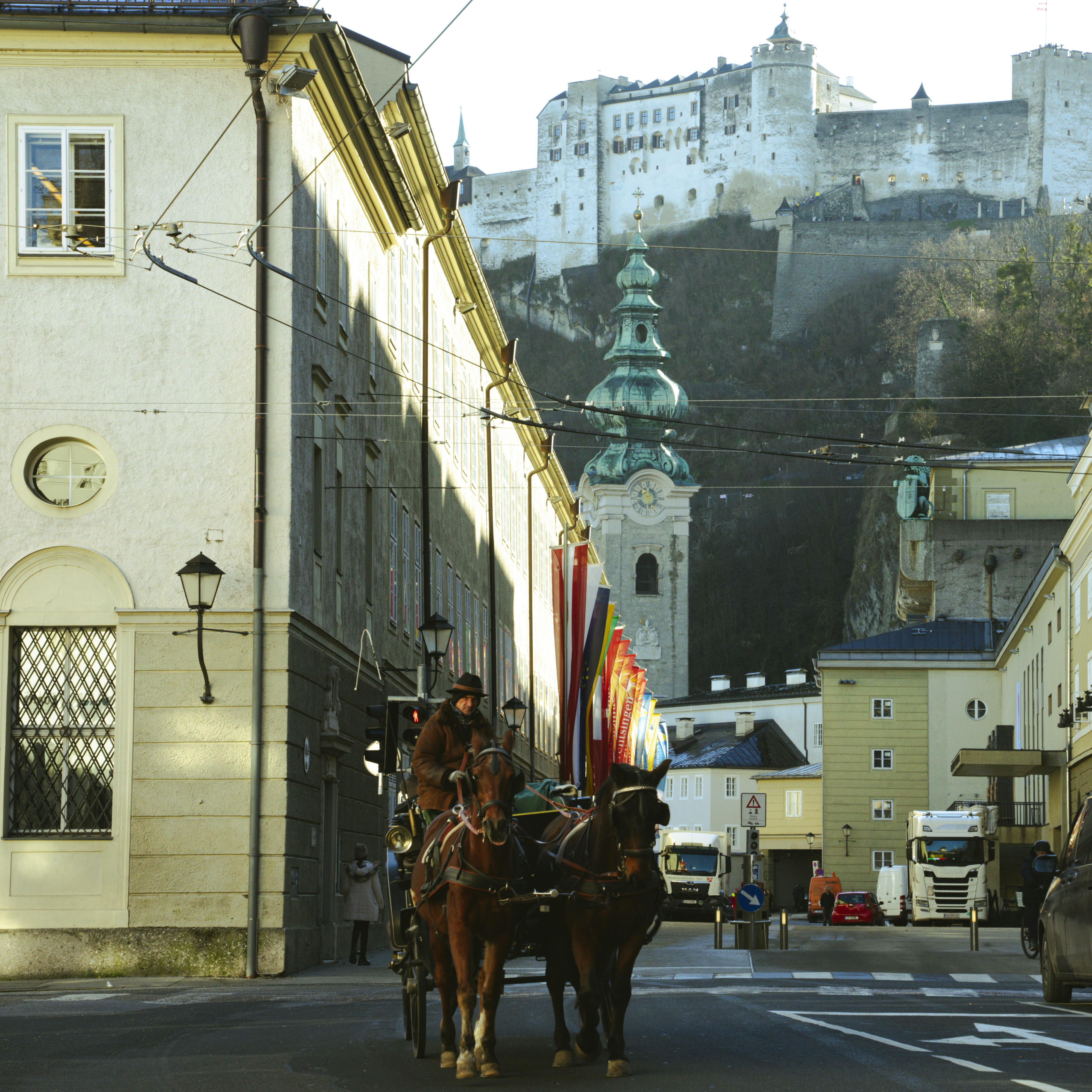 cortege: A horse-drawn carriage travels a historic street below a castle