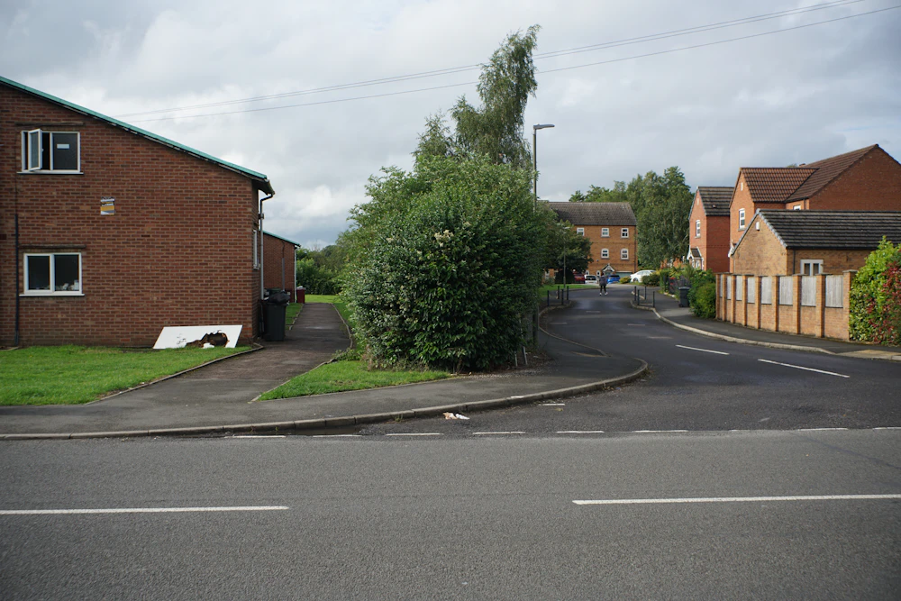 A residential street of brick houses lined with trees