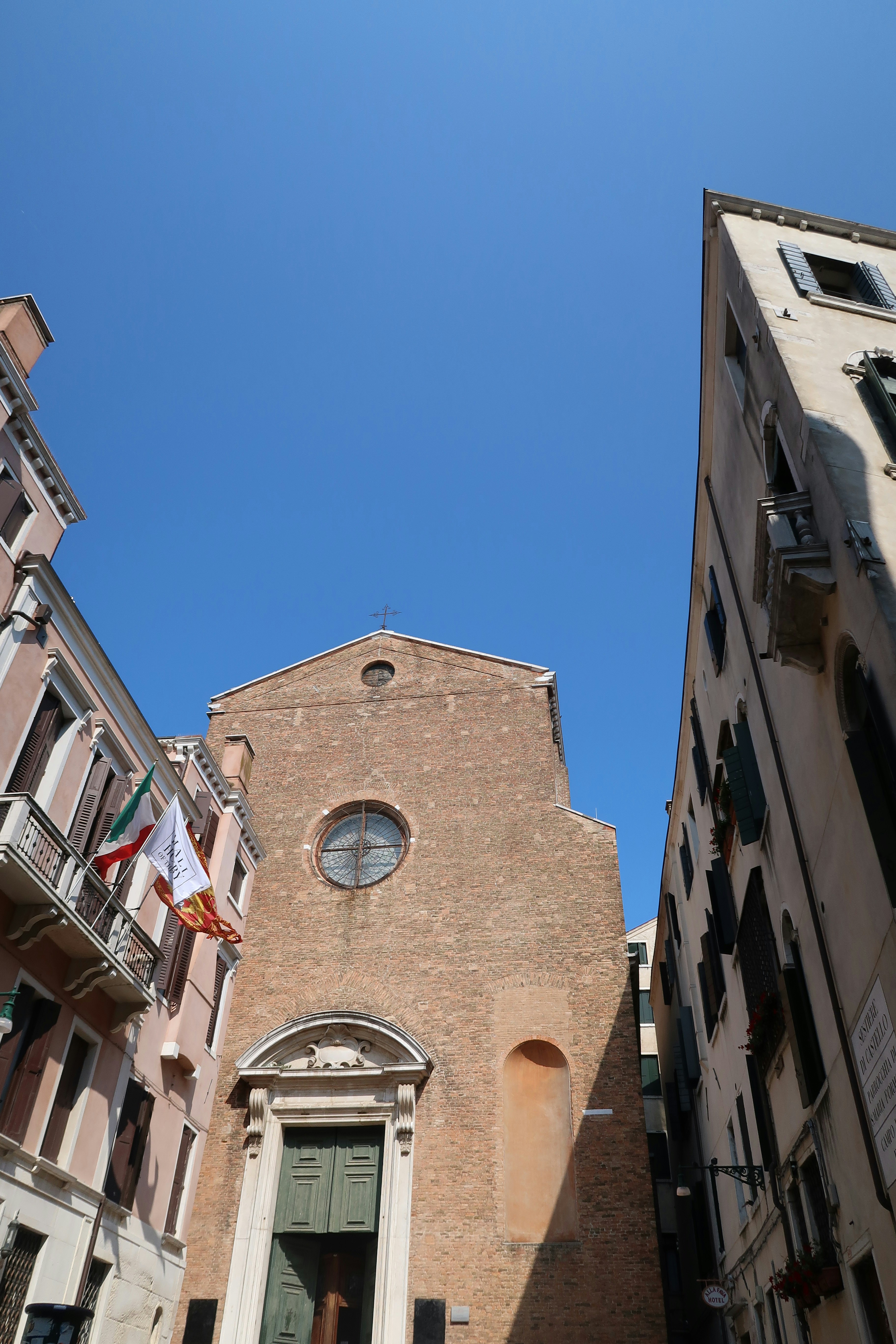 Backsteinkirche und alte Gebäude unter klarem blauen Himmel.