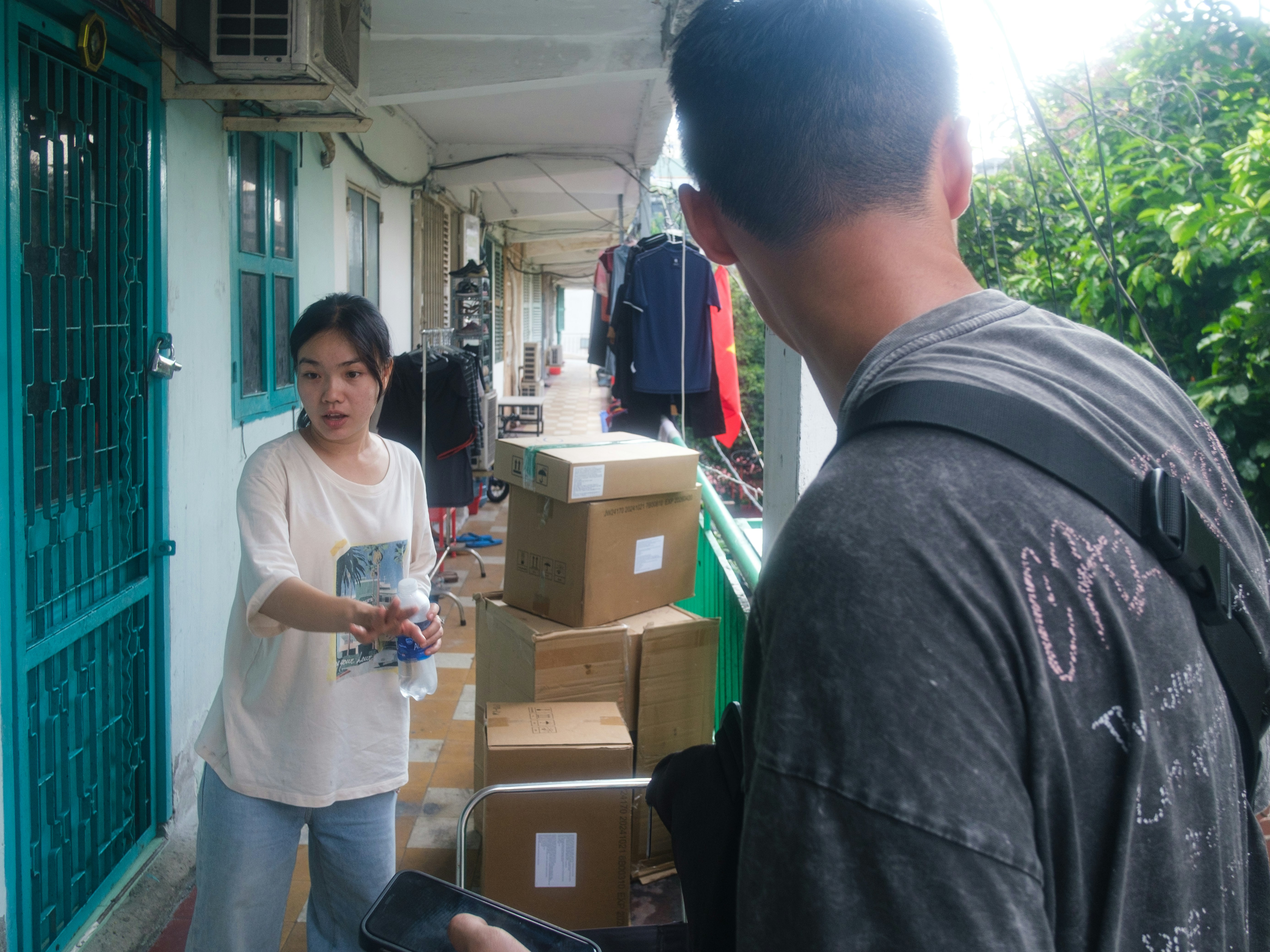 Woman on a balcony beside stacked moving boxes