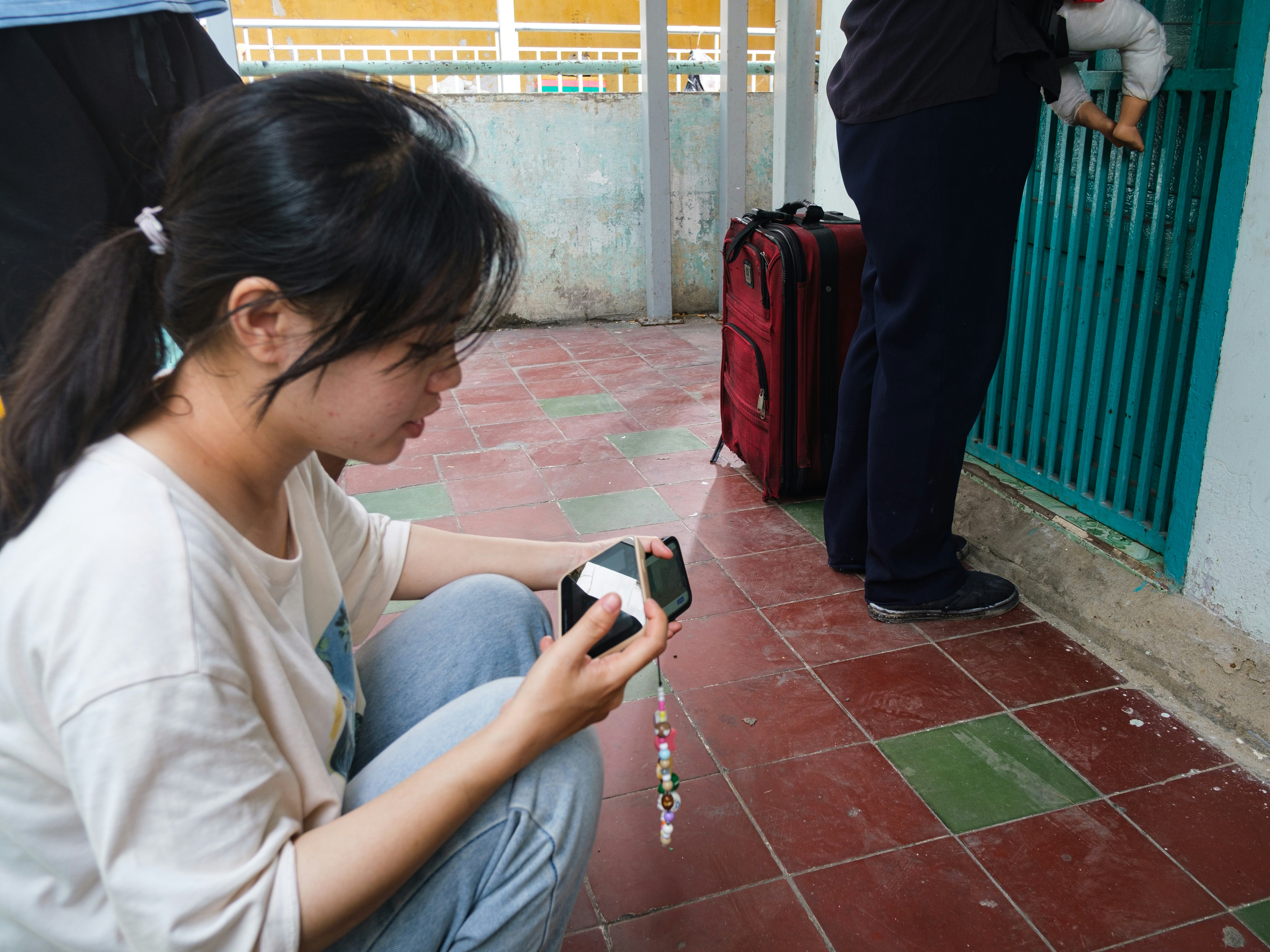 Young woman crouching and looking at her smartphone.