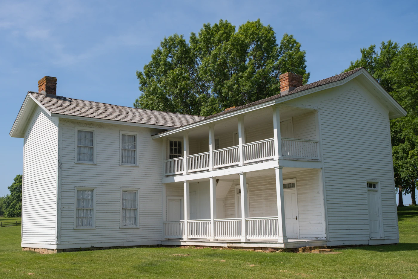 White two-story farmhouse with a double porch
