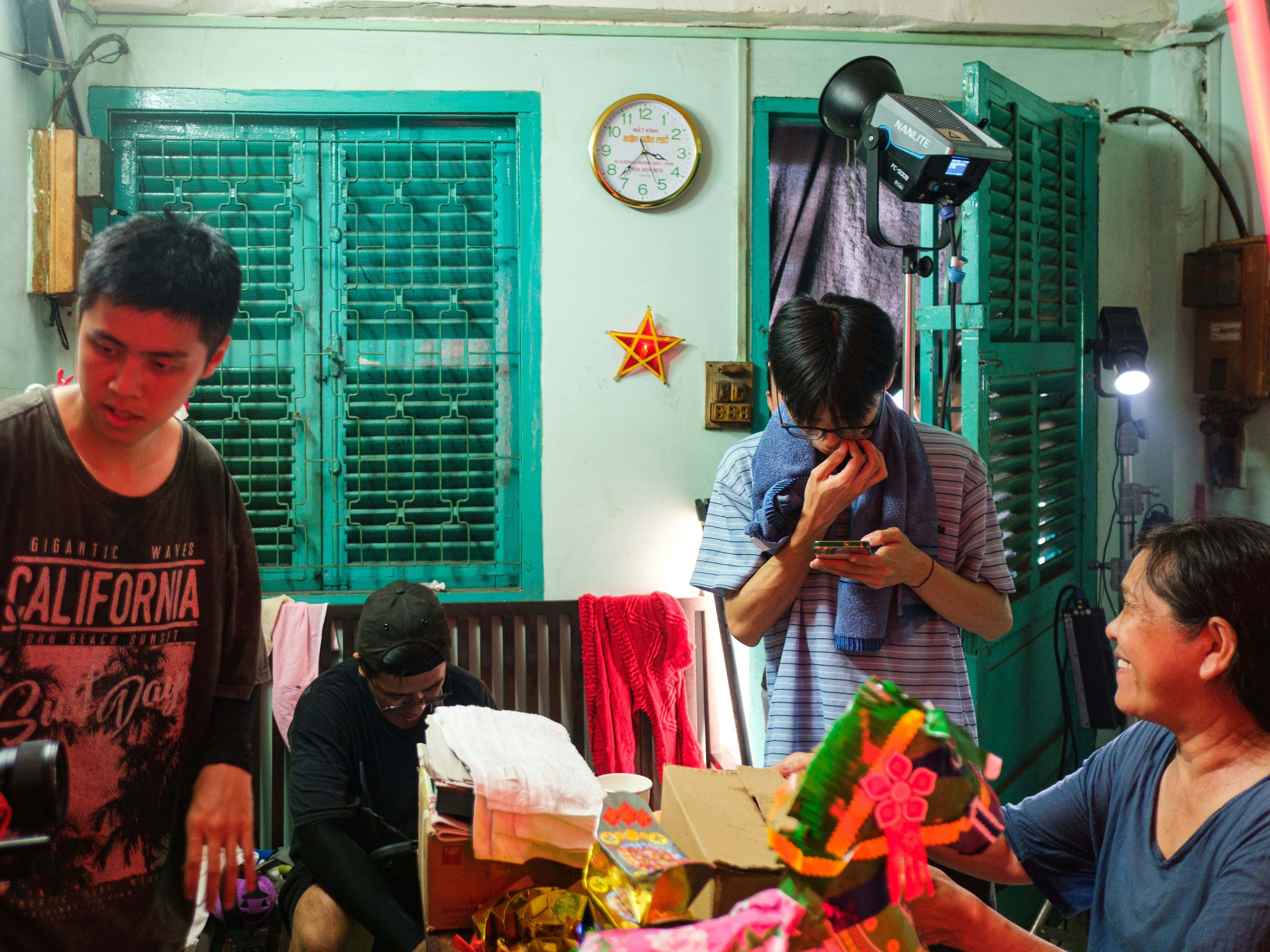 Four people gathered in a room with green windows