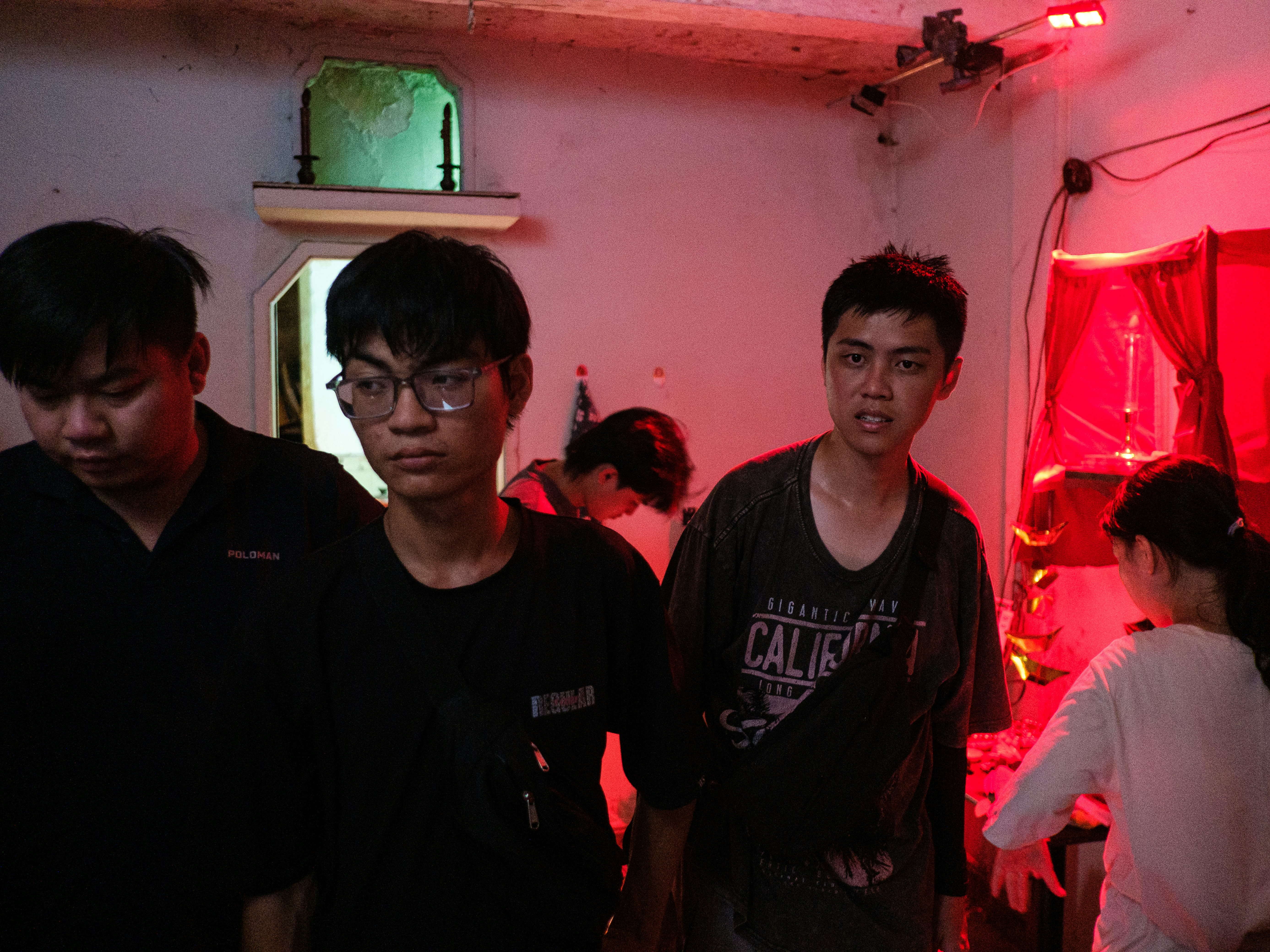 Young people in a dimly lit room with red lighting