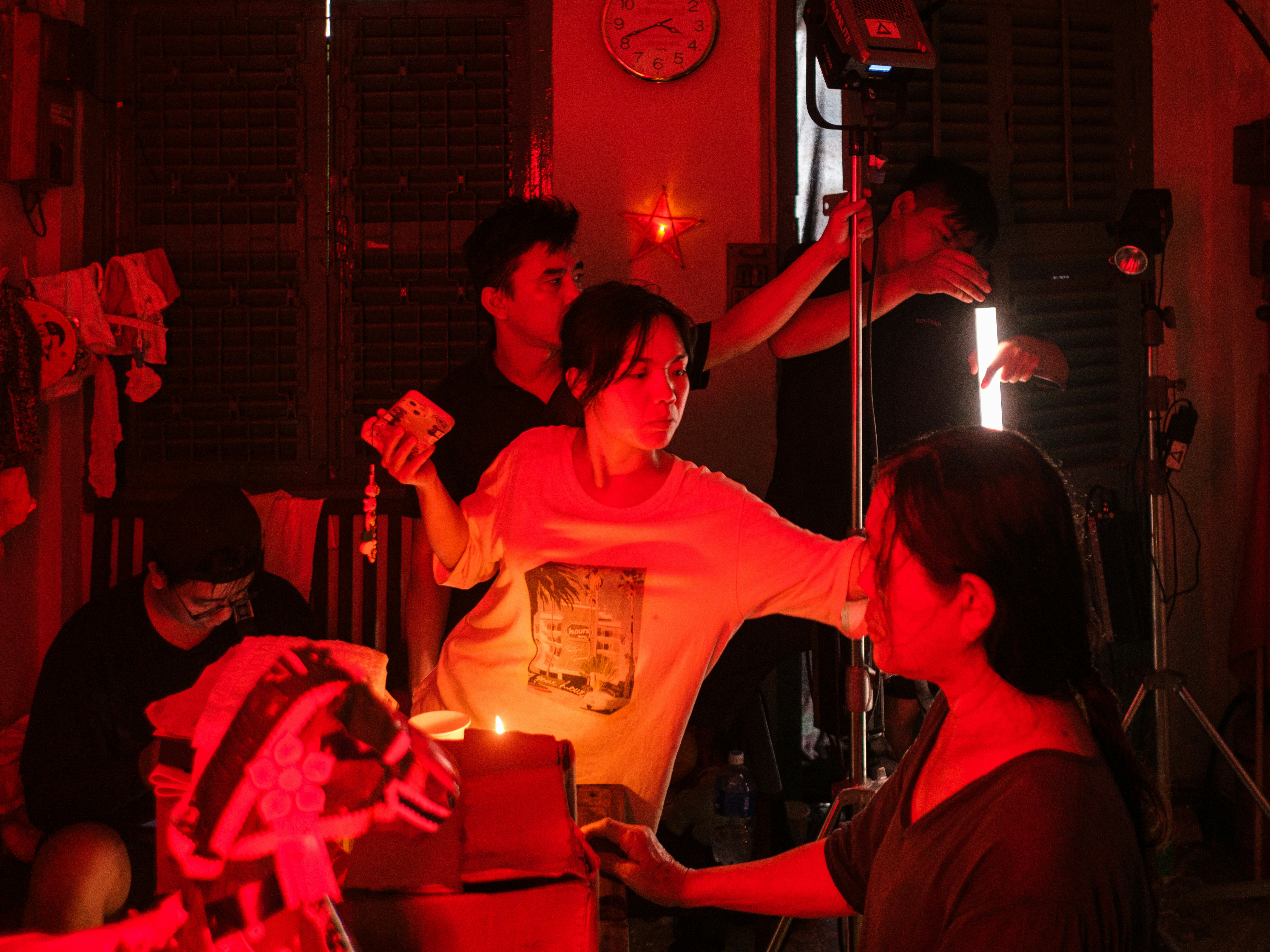 Filmmakers working on set under dramatic red lighting