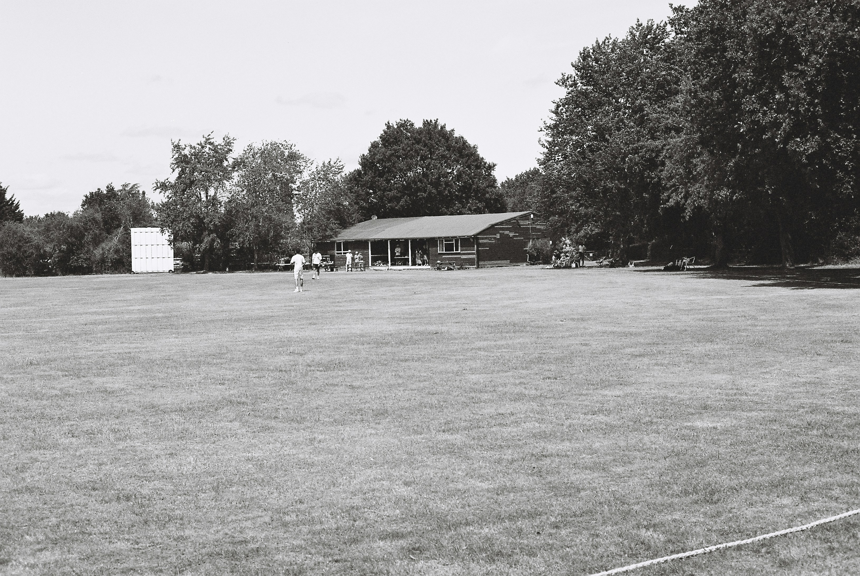 Campo de críquete preto e branco com pavilhão