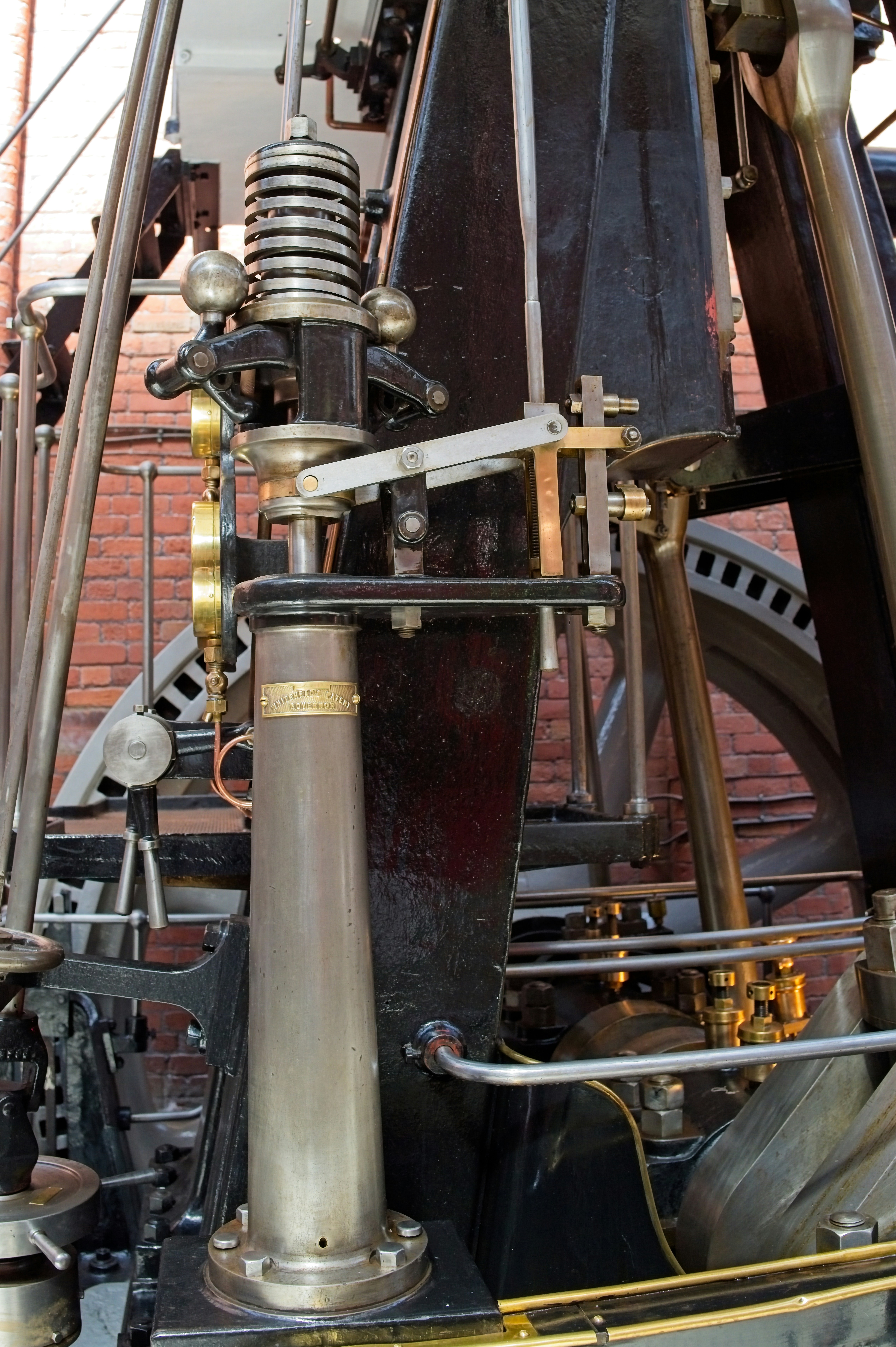 Intricate mechanical components of an old industrial steam engine.