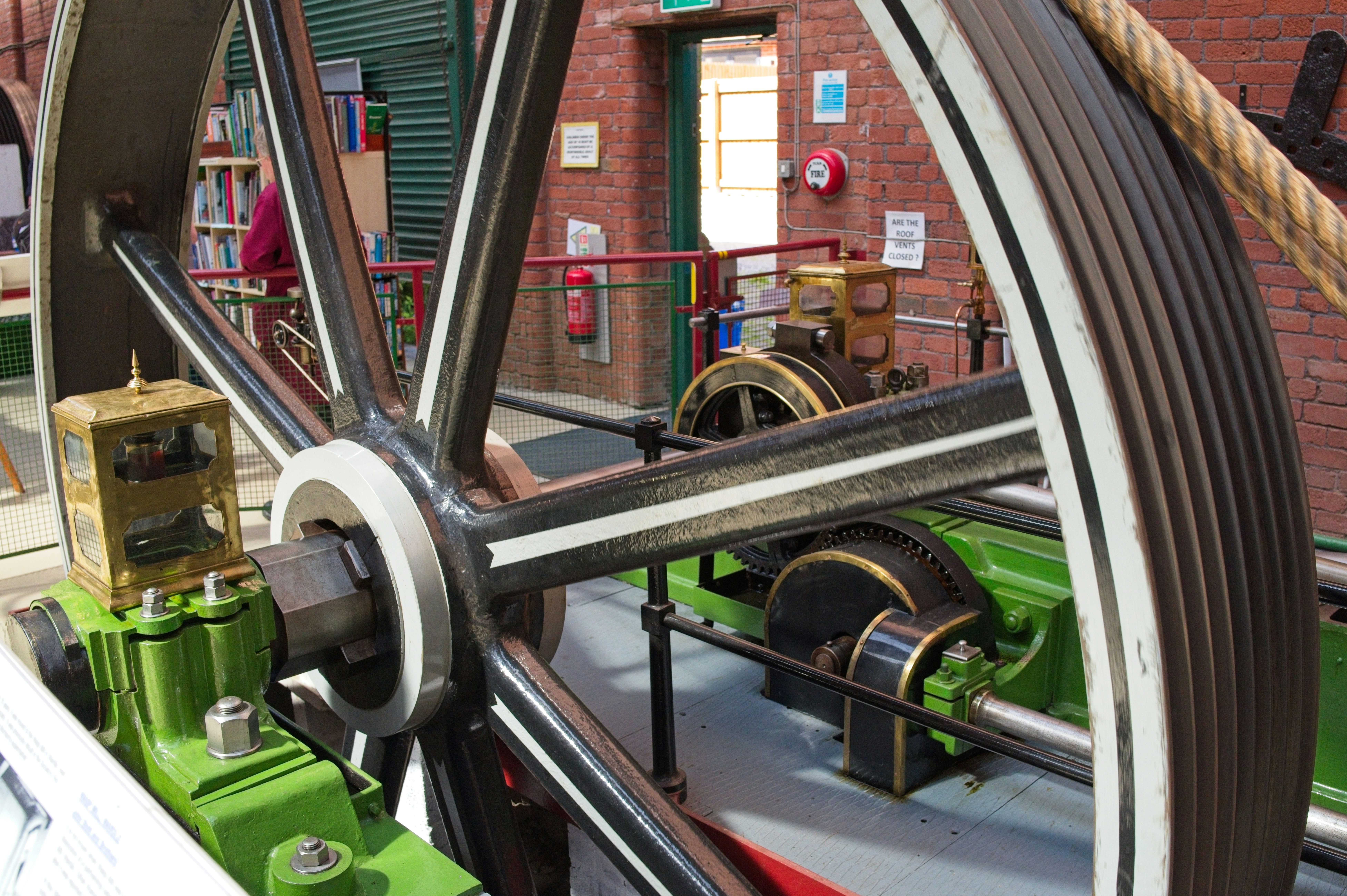 Large industrial flywheel and machinery in a historical building.