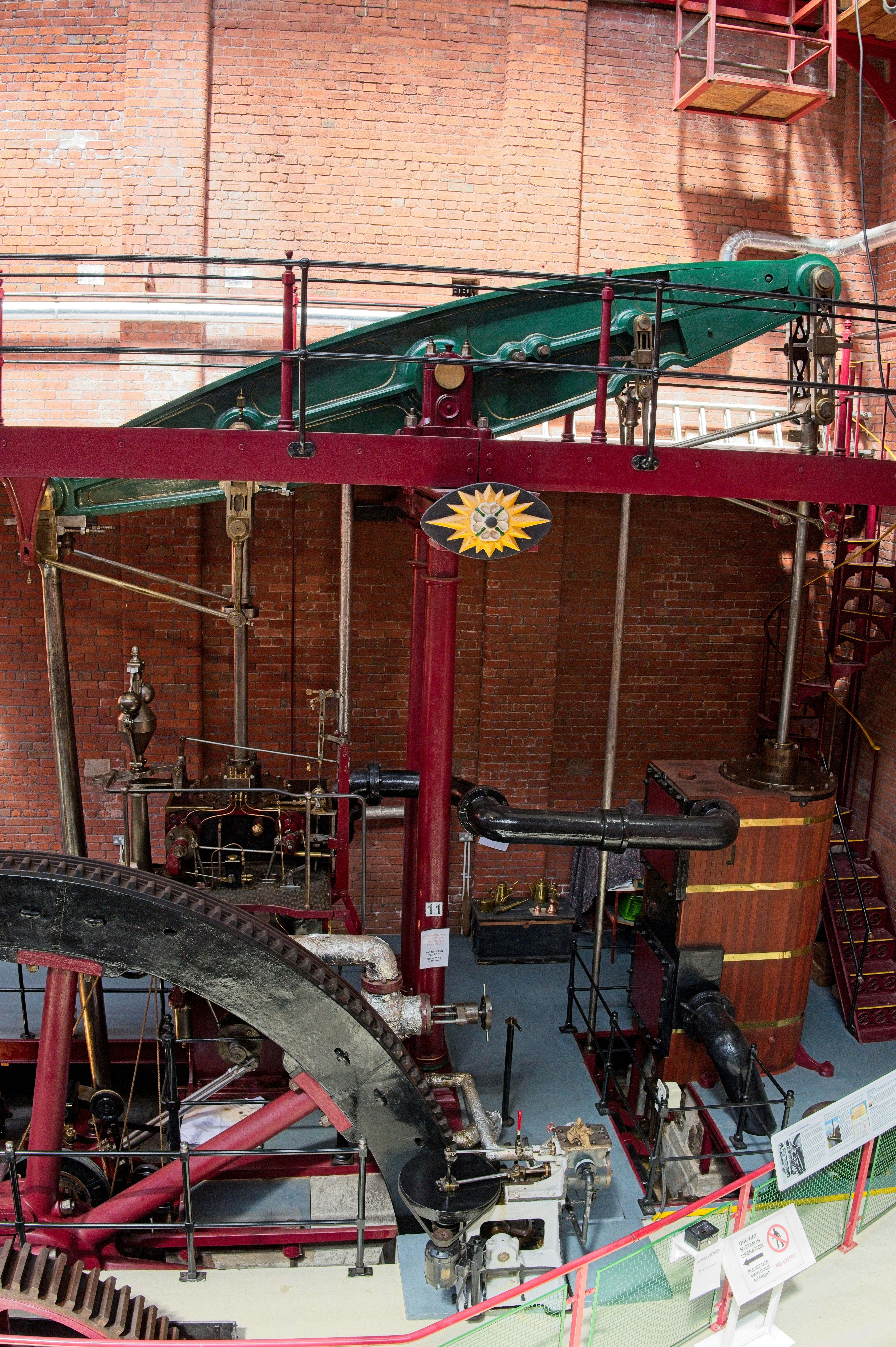 Machine industrielle vintage complexe avec engrenages, tuyaux et réservoir en bois.