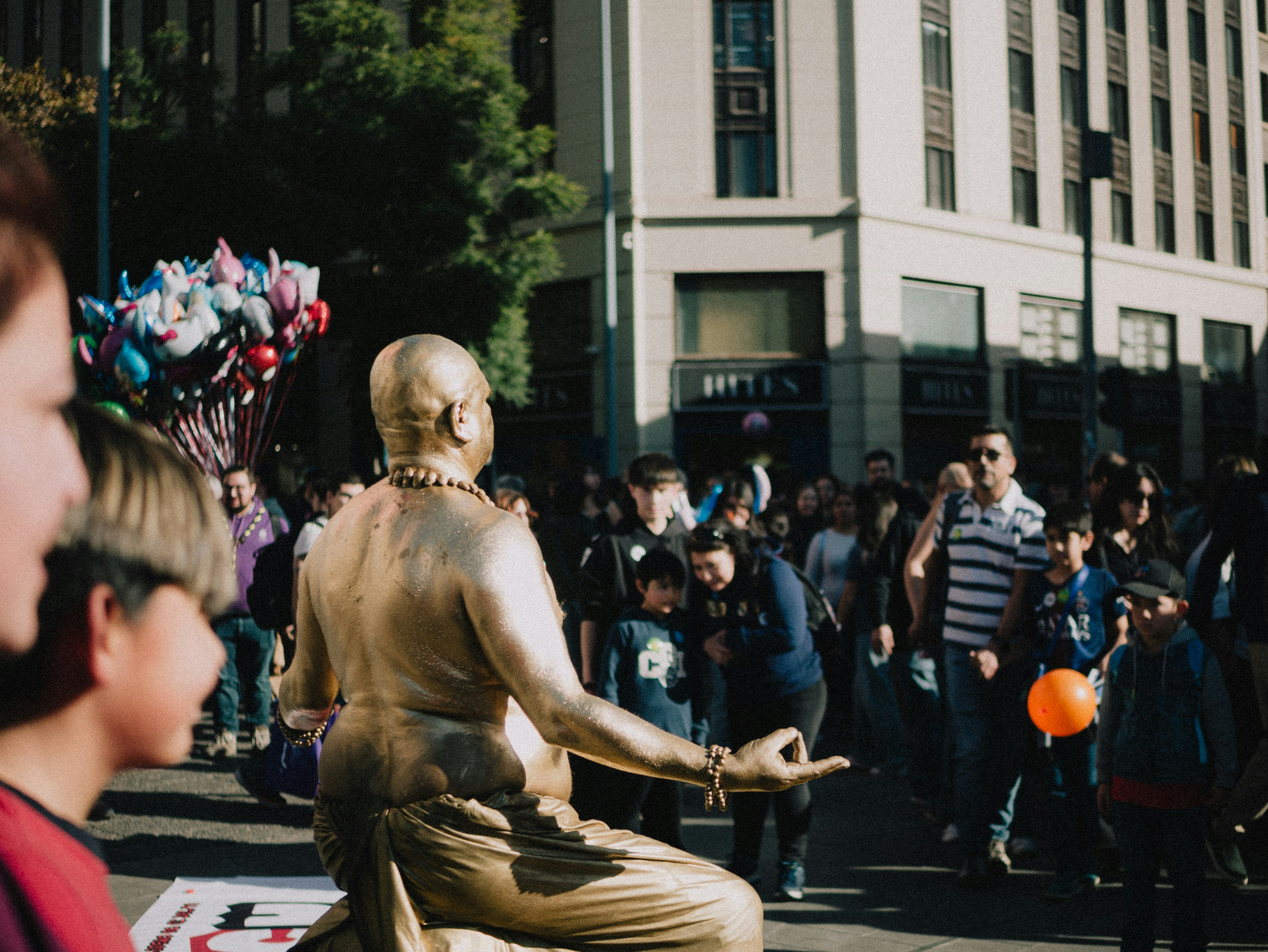 Golden living statue in a city street crowd.