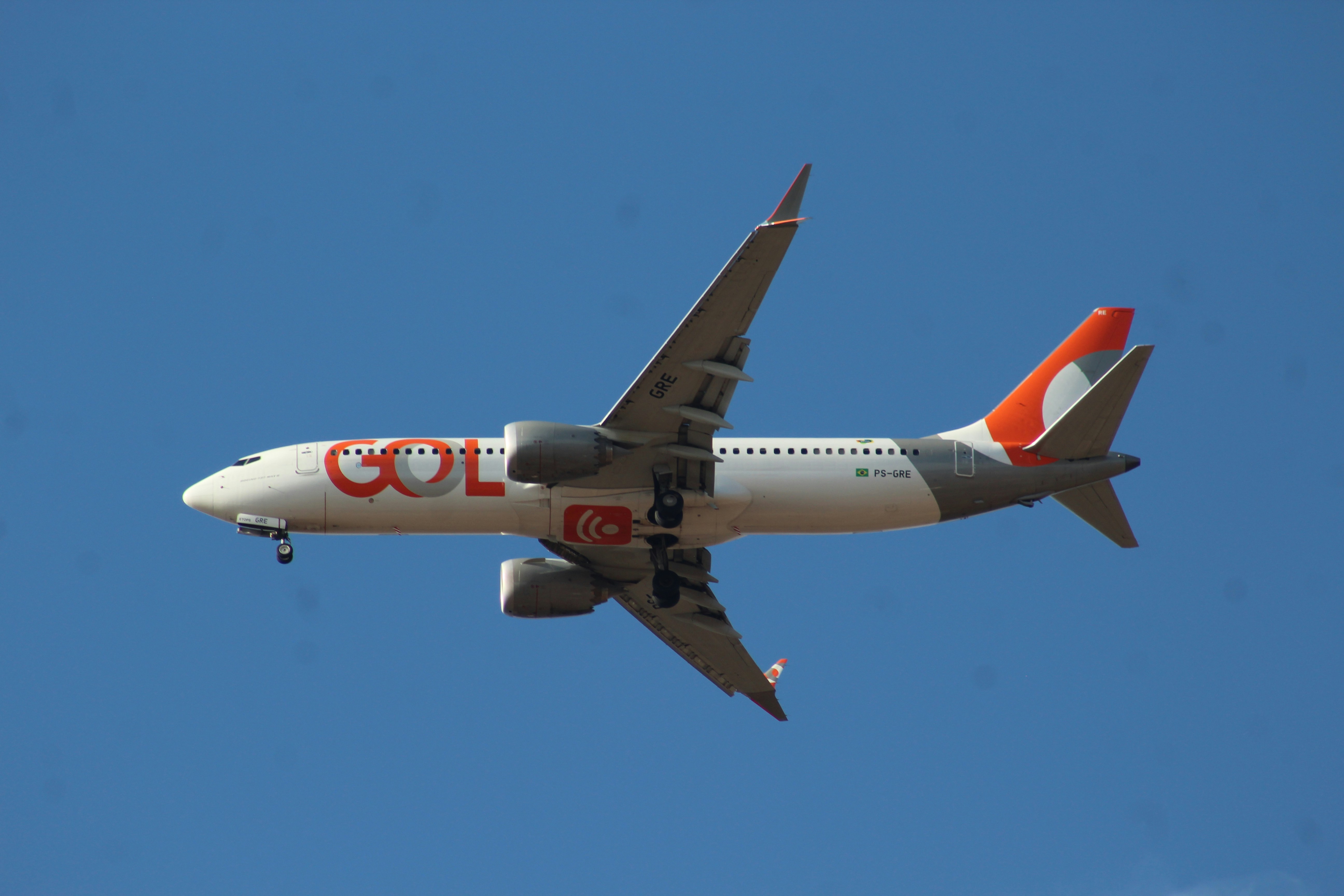 A gol airplane flying in a clear blue sky.