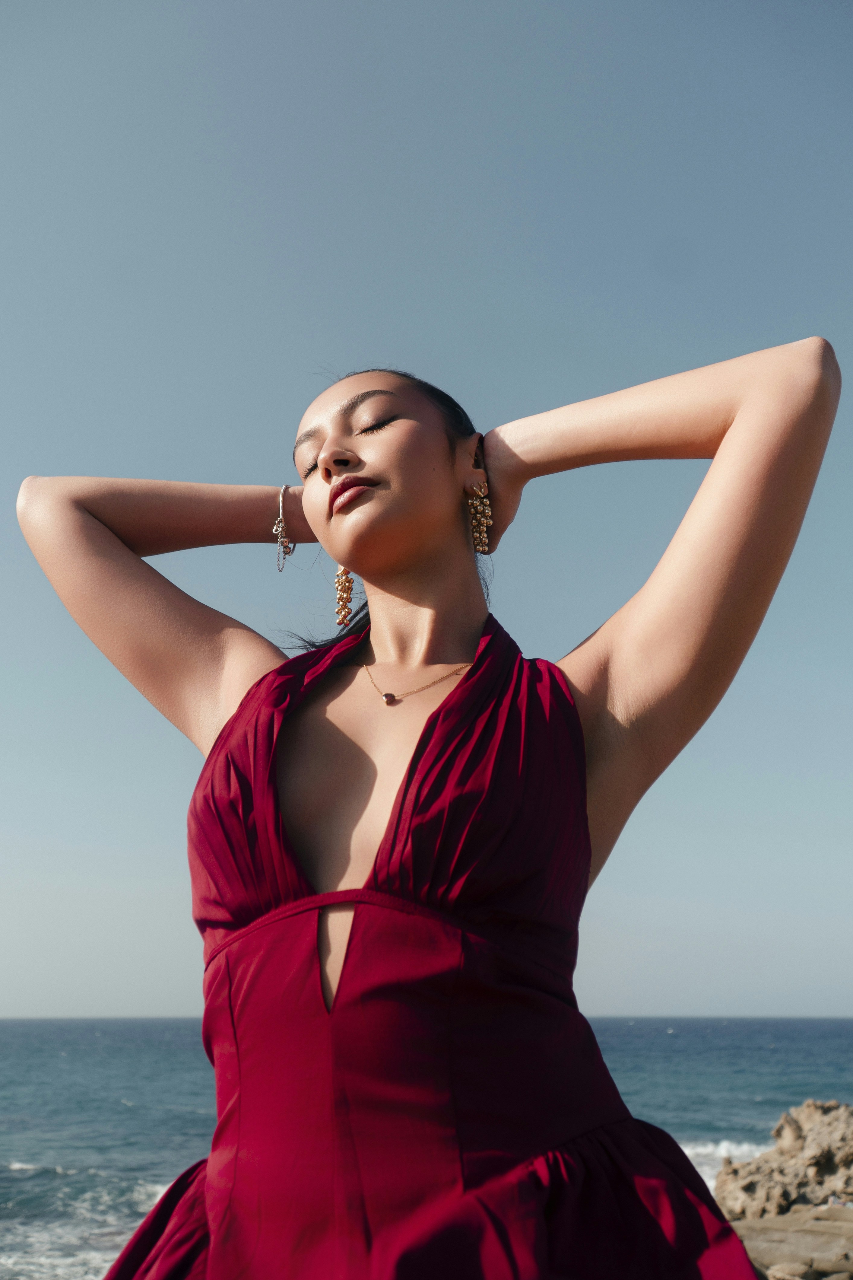 Woman in red dress relaxing by the ocean