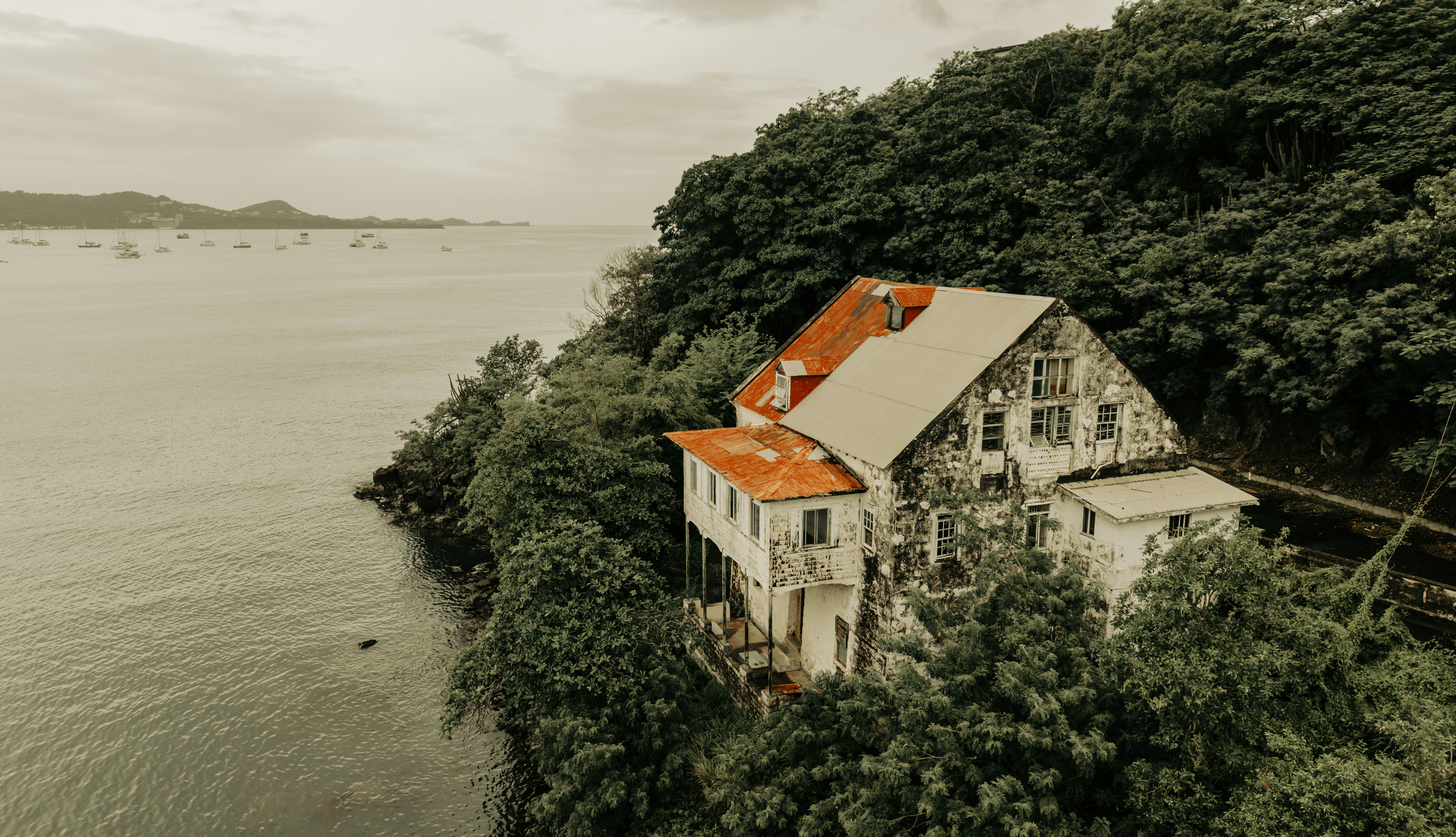 Casa fatiscente su una rigogliosa scogliera accanto al mare.