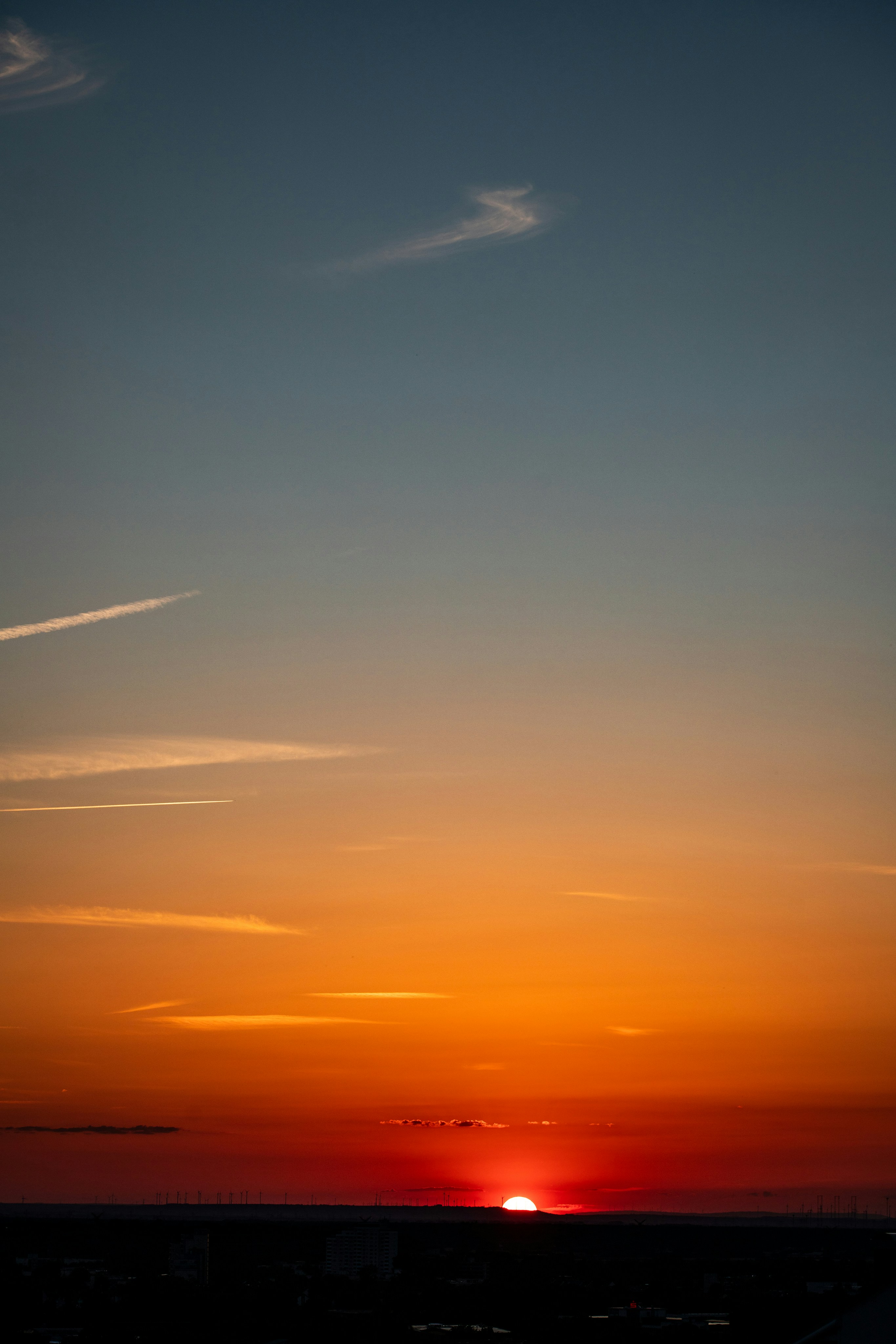 Vibrant orange and red sunset over a dark horizon.