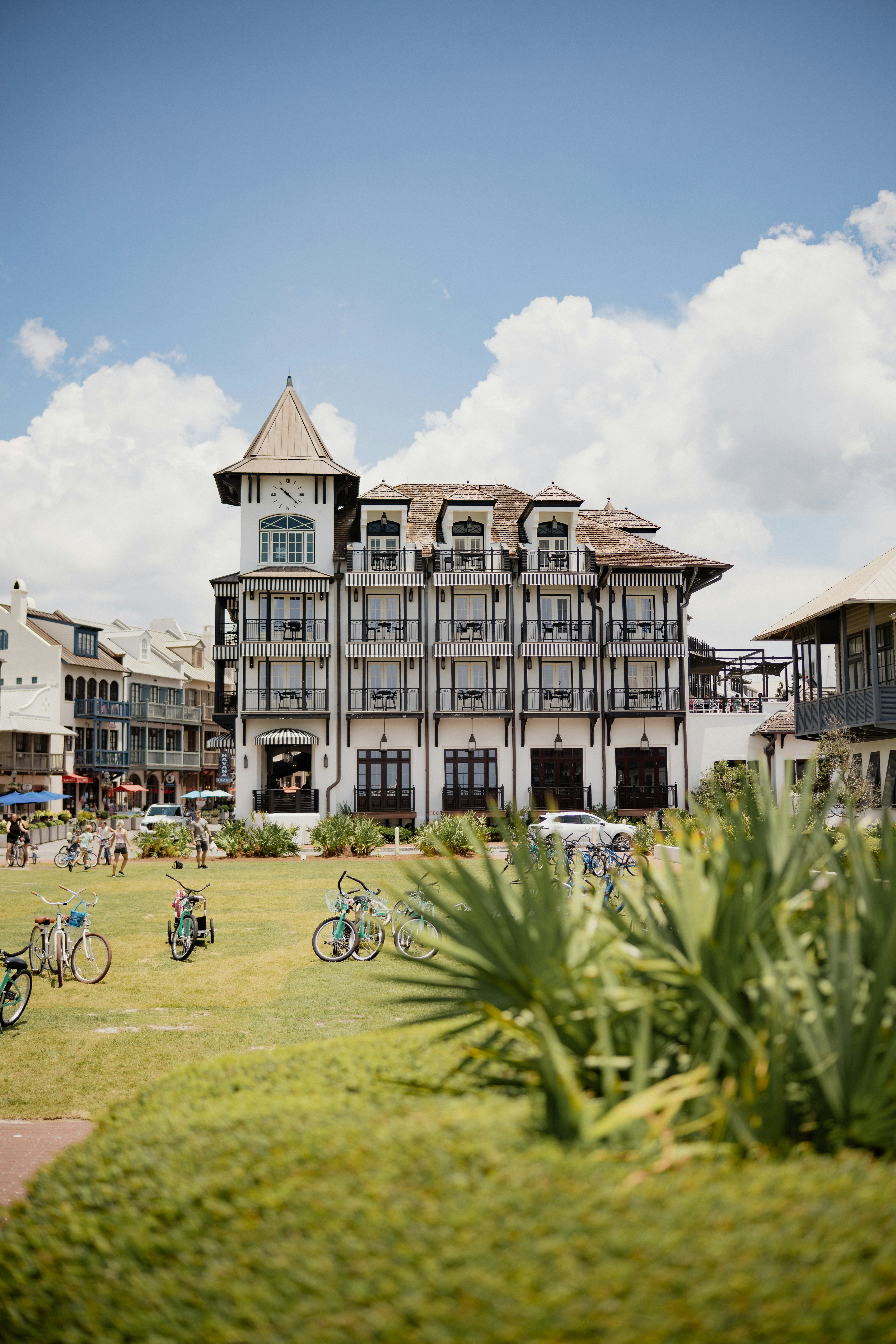Elegant white building overlooks a green lawn with parked bicycles.