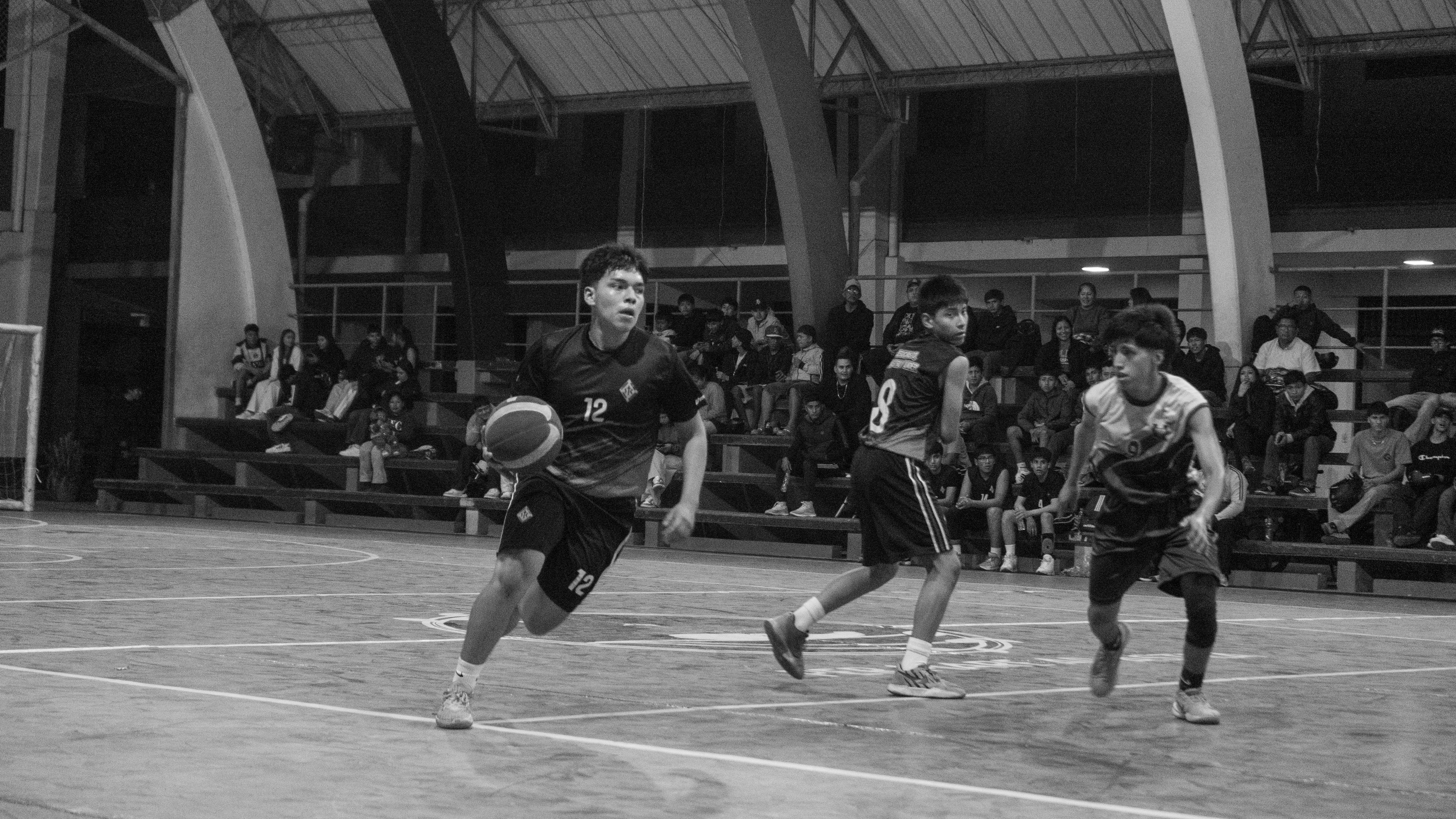 Seorang pemain bola basket menggiring bola selama pertandingan.