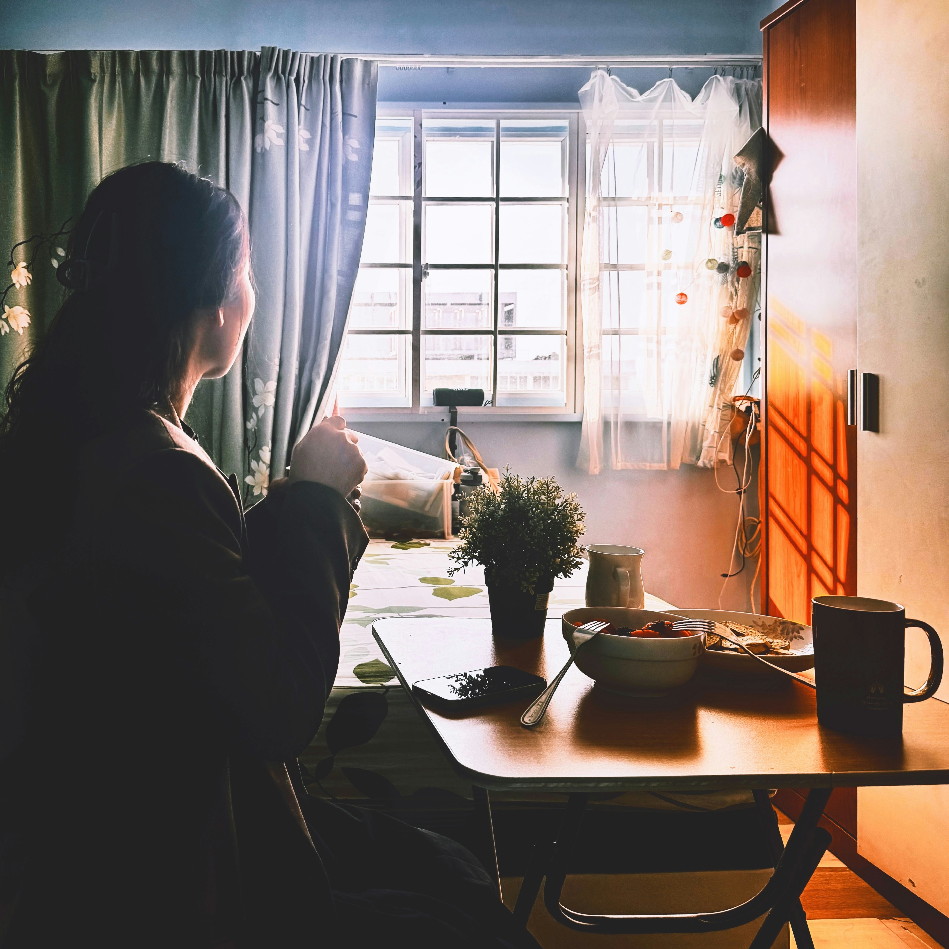 Wanita menikmati kopi pagi dengan cahaya jendela.