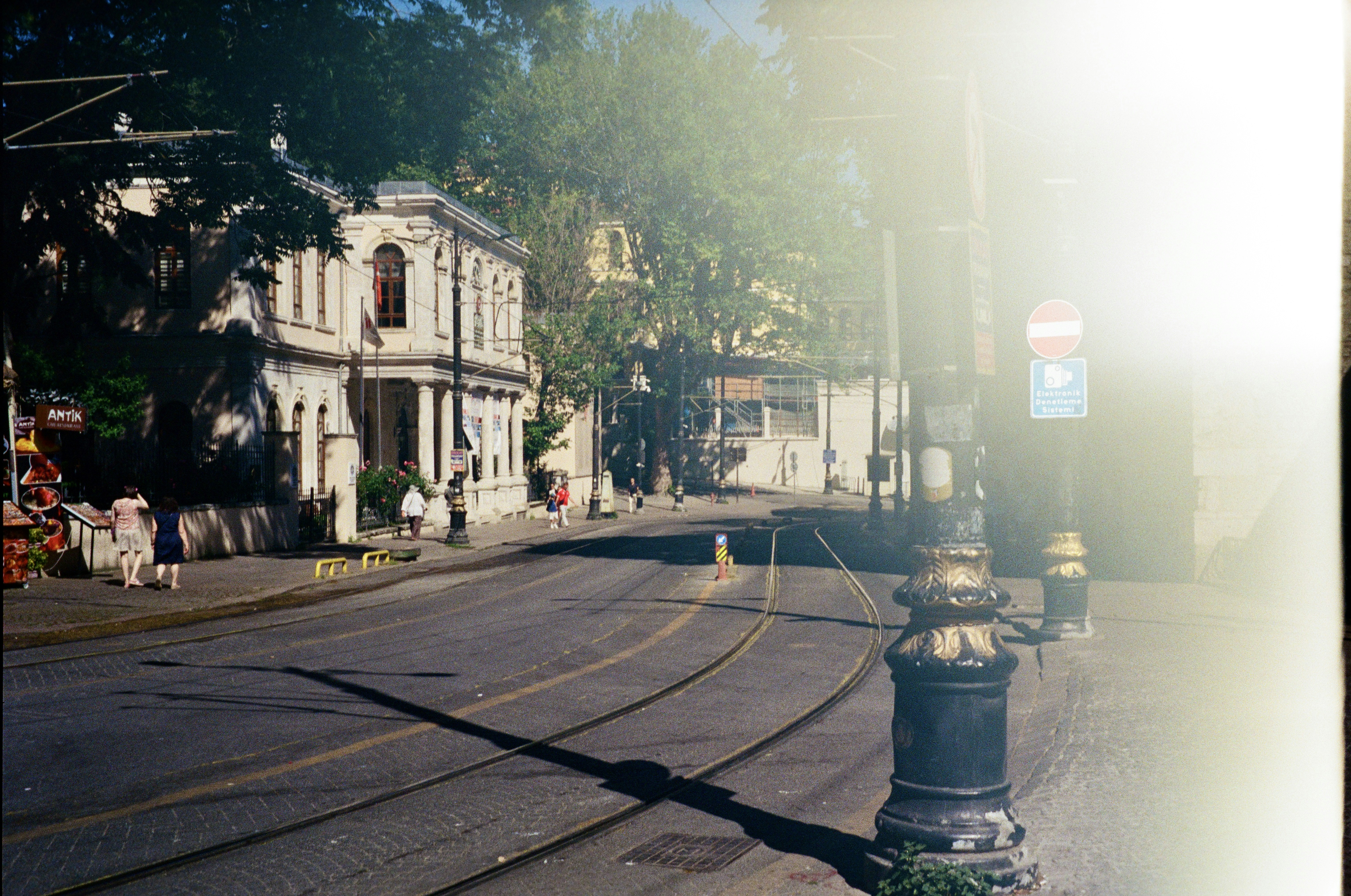 Tram tracks curving through a sunlit street