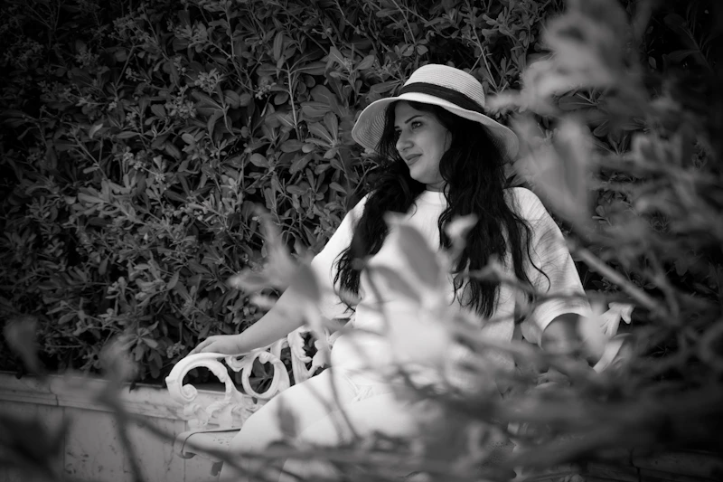charming woman in a hat on a garden bench