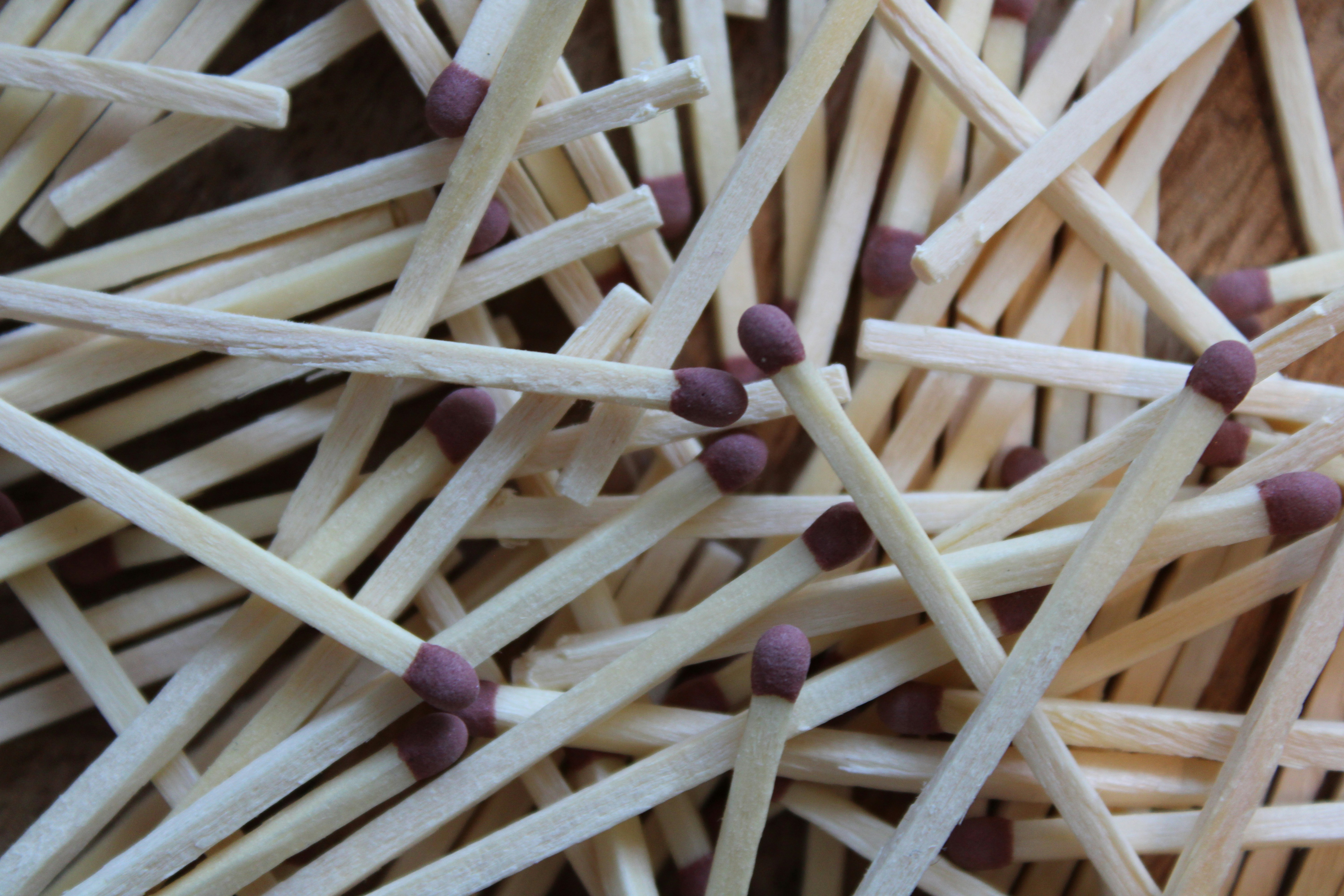A pile of wooden matches with purple heads scattered