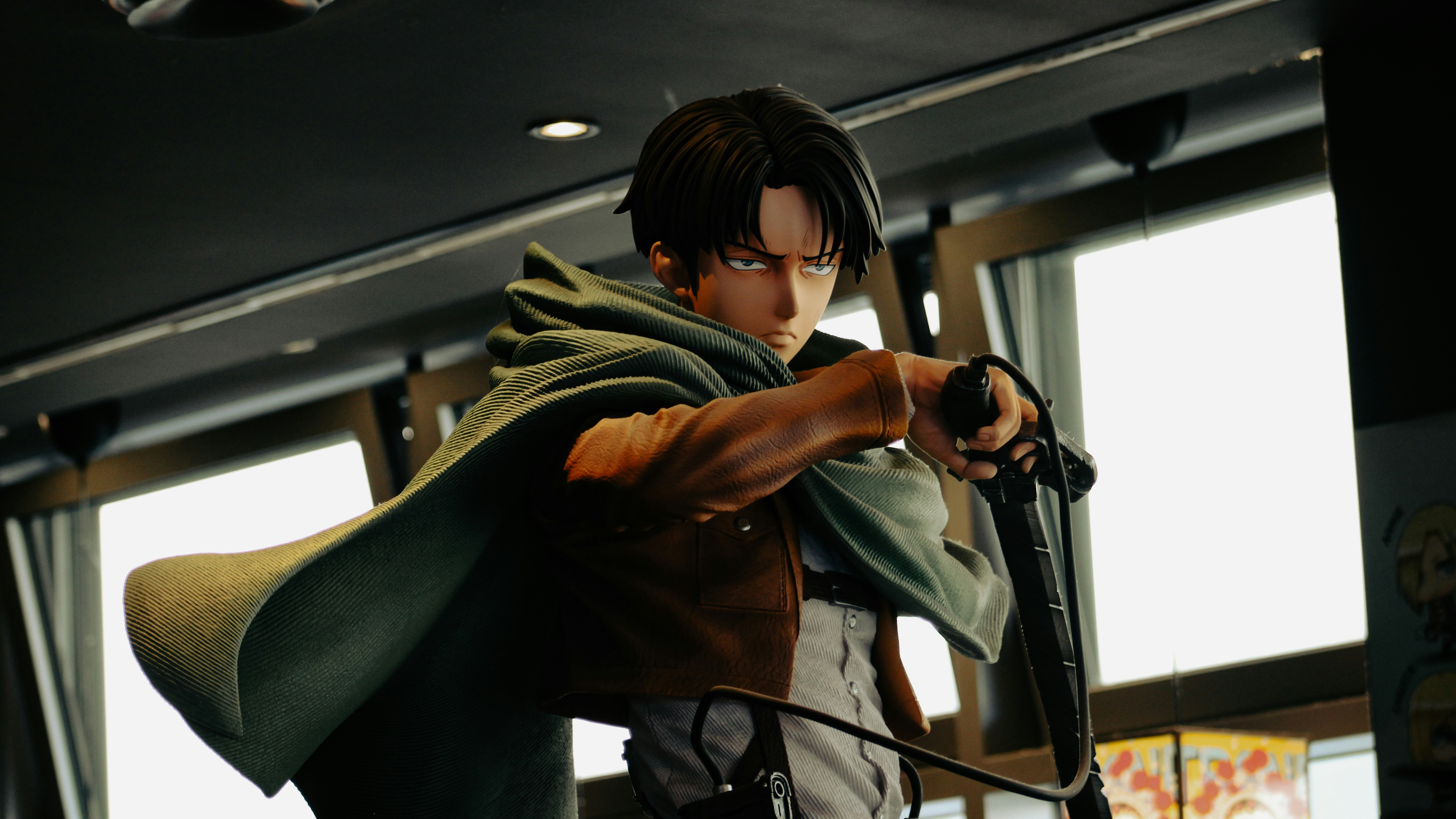 Sosok Levi ackerman dalam pose dinamis dengan jubah.
