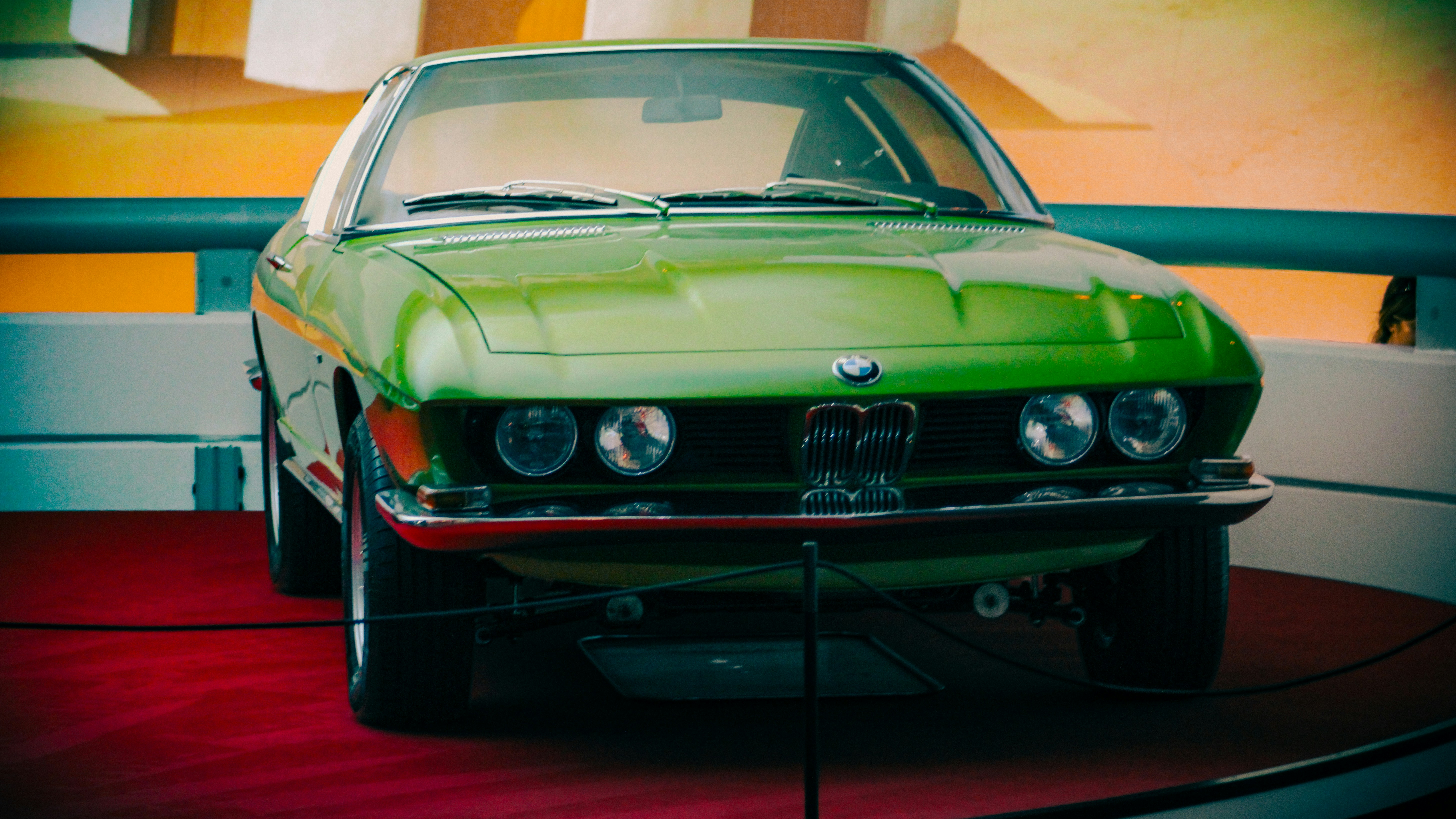 Ein grüner Oldtimer auf einem roten Teppich.