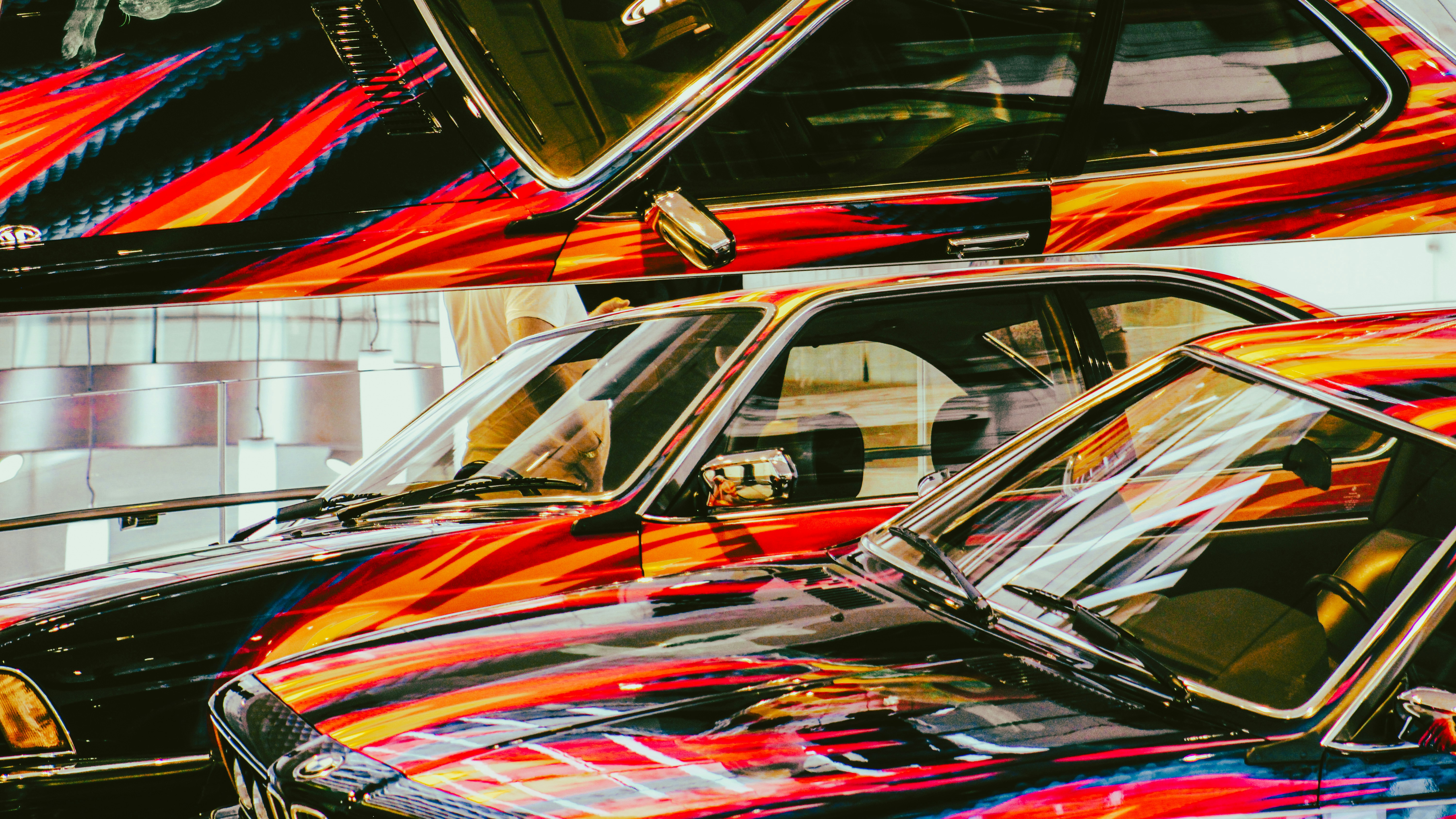 Mehrere Autos mit lebendigen, abstrakten roten und orangen Mustern.