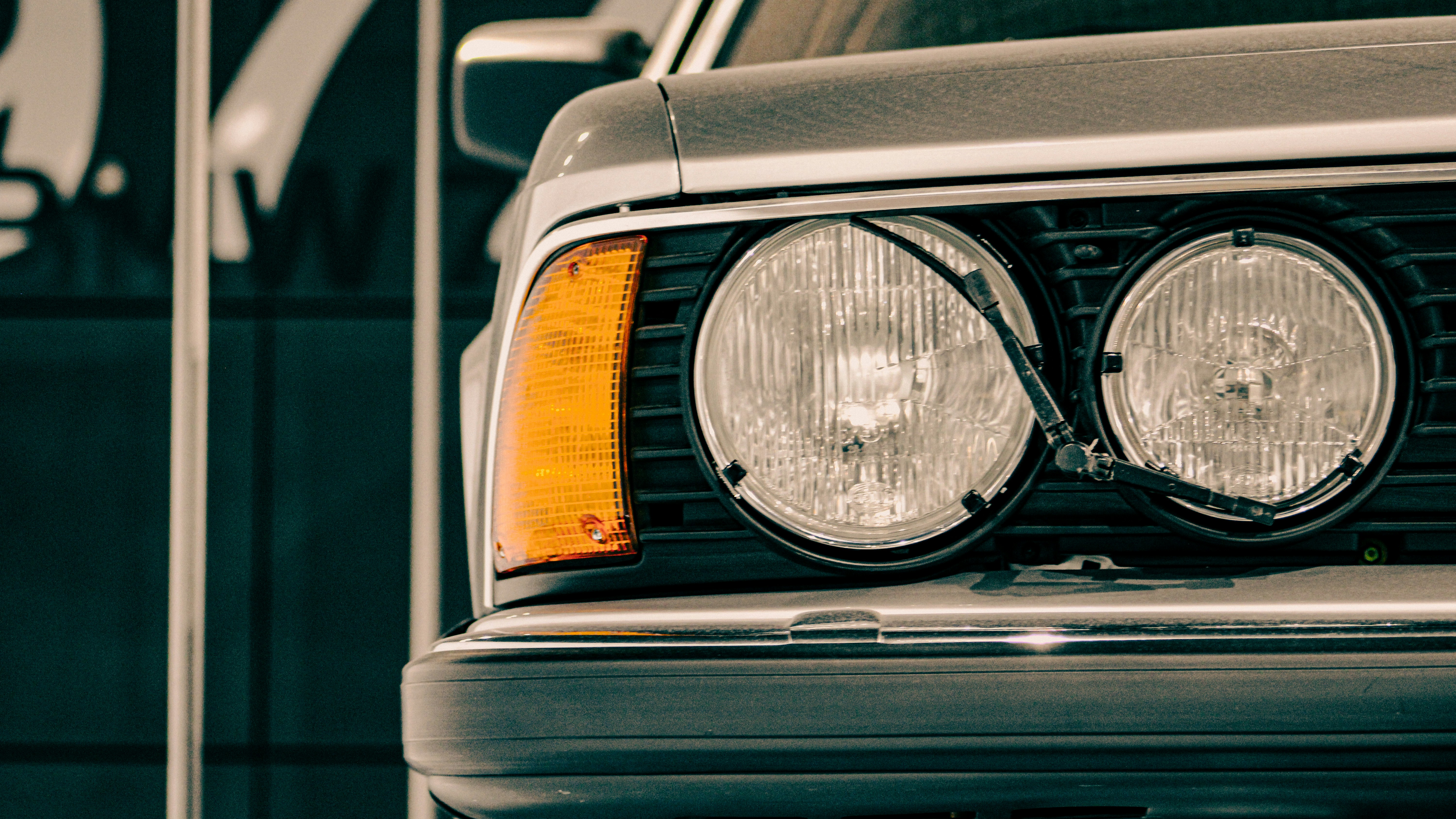 Der Scheinwerfer und der bernsteinfarbene Blinker des klassischen grauen Autos.