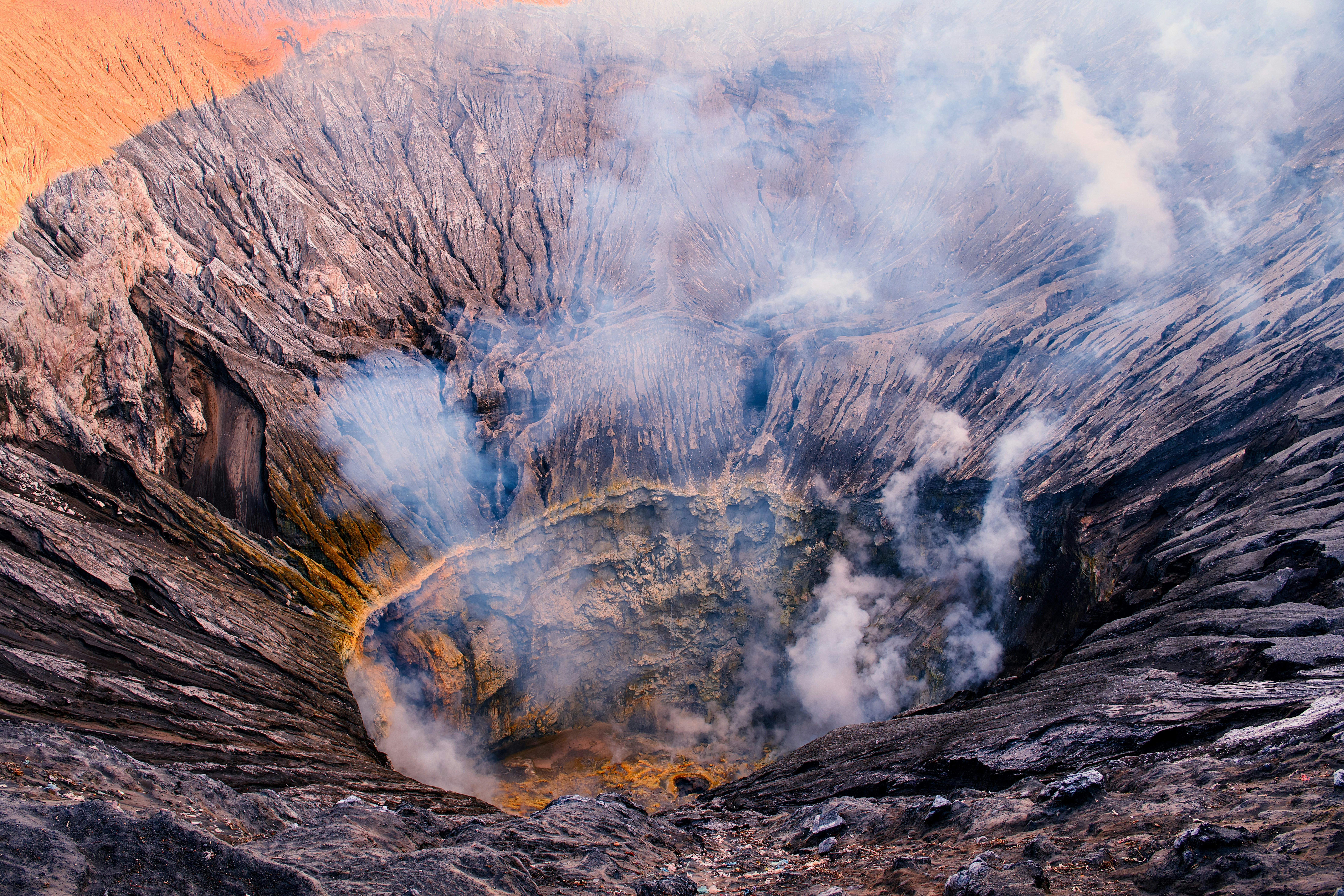 Smoke billows from an active volcanic crater.
