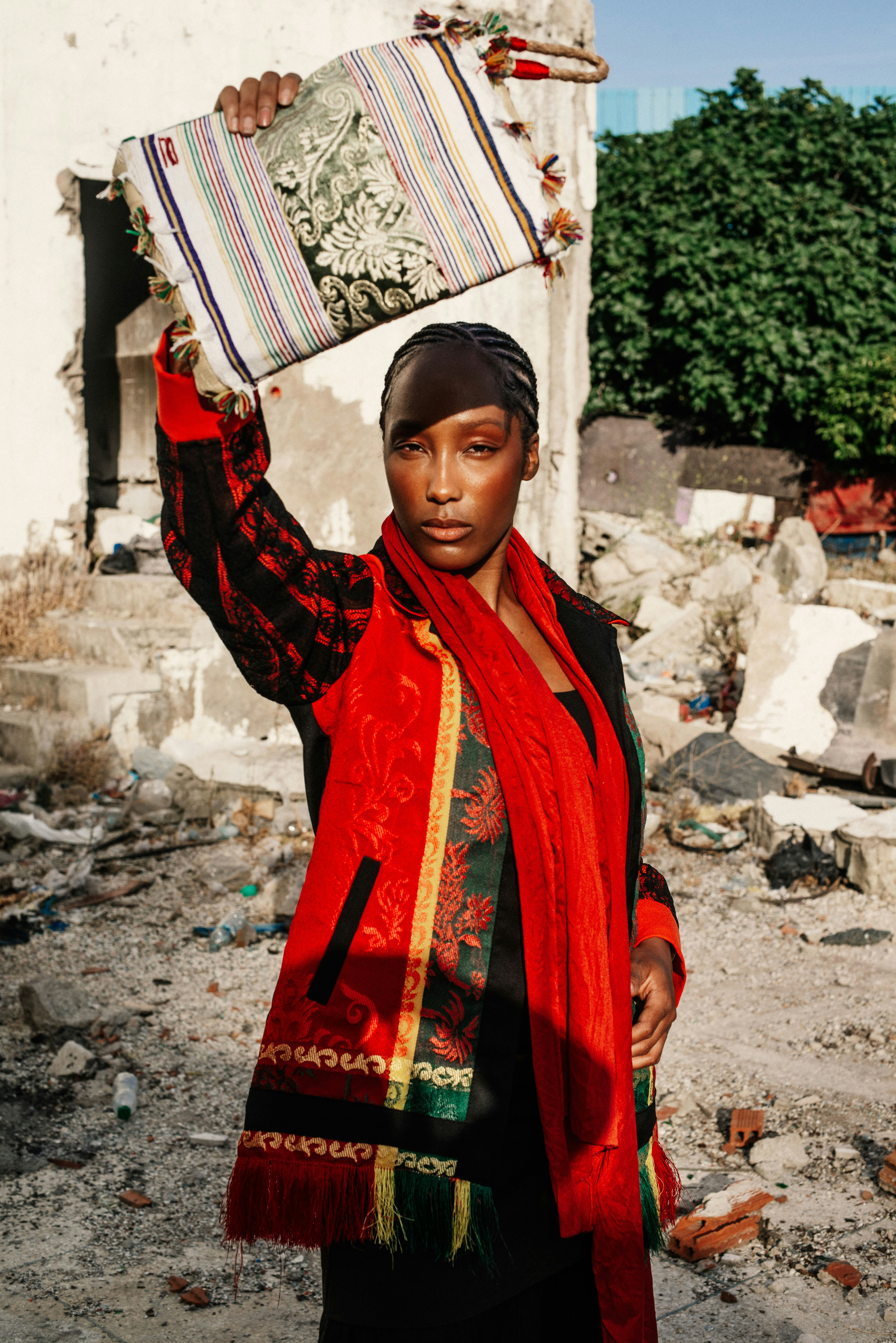Woman holding patterned bag amidst urban ruins