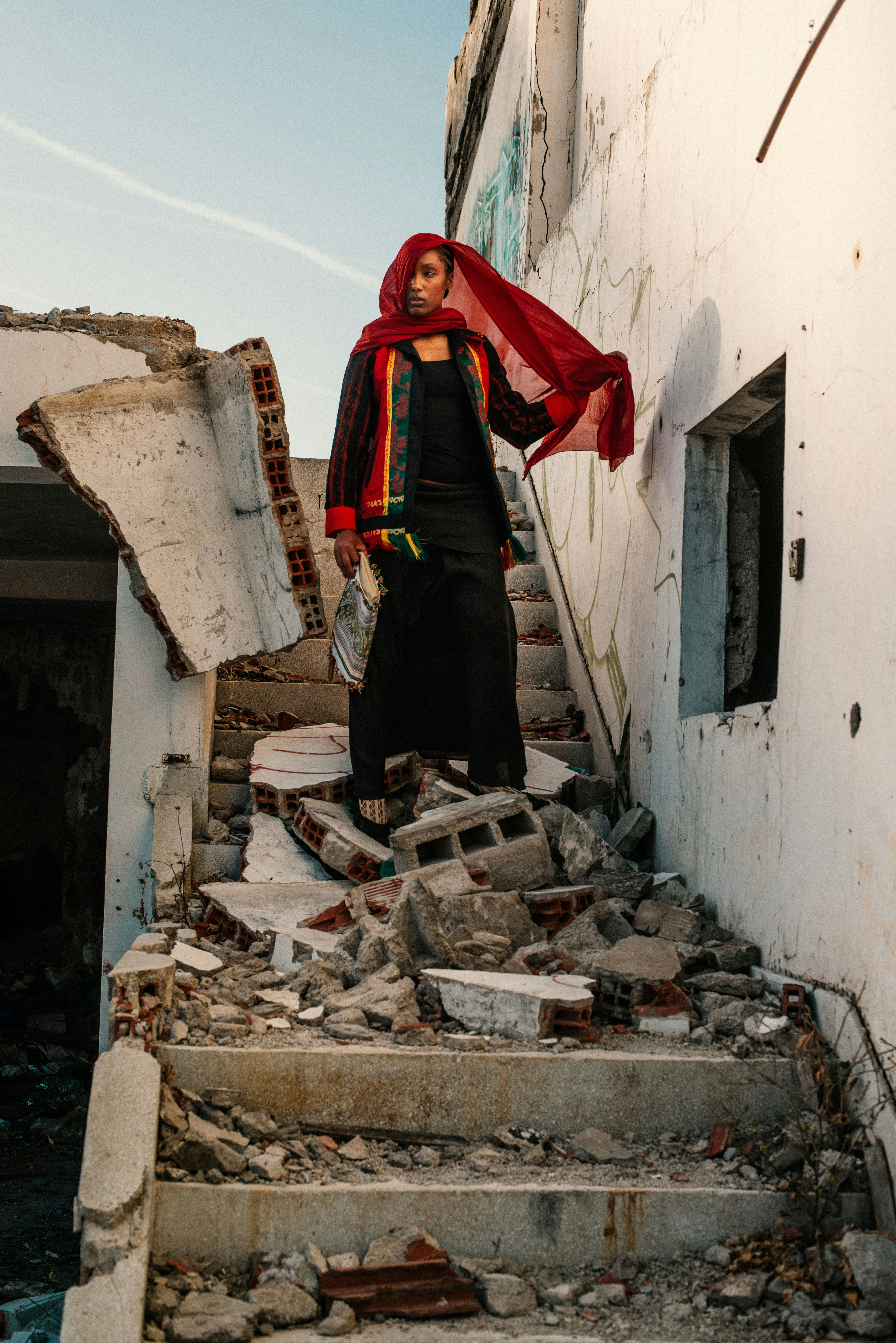 Woman in red veil on ruined staircase