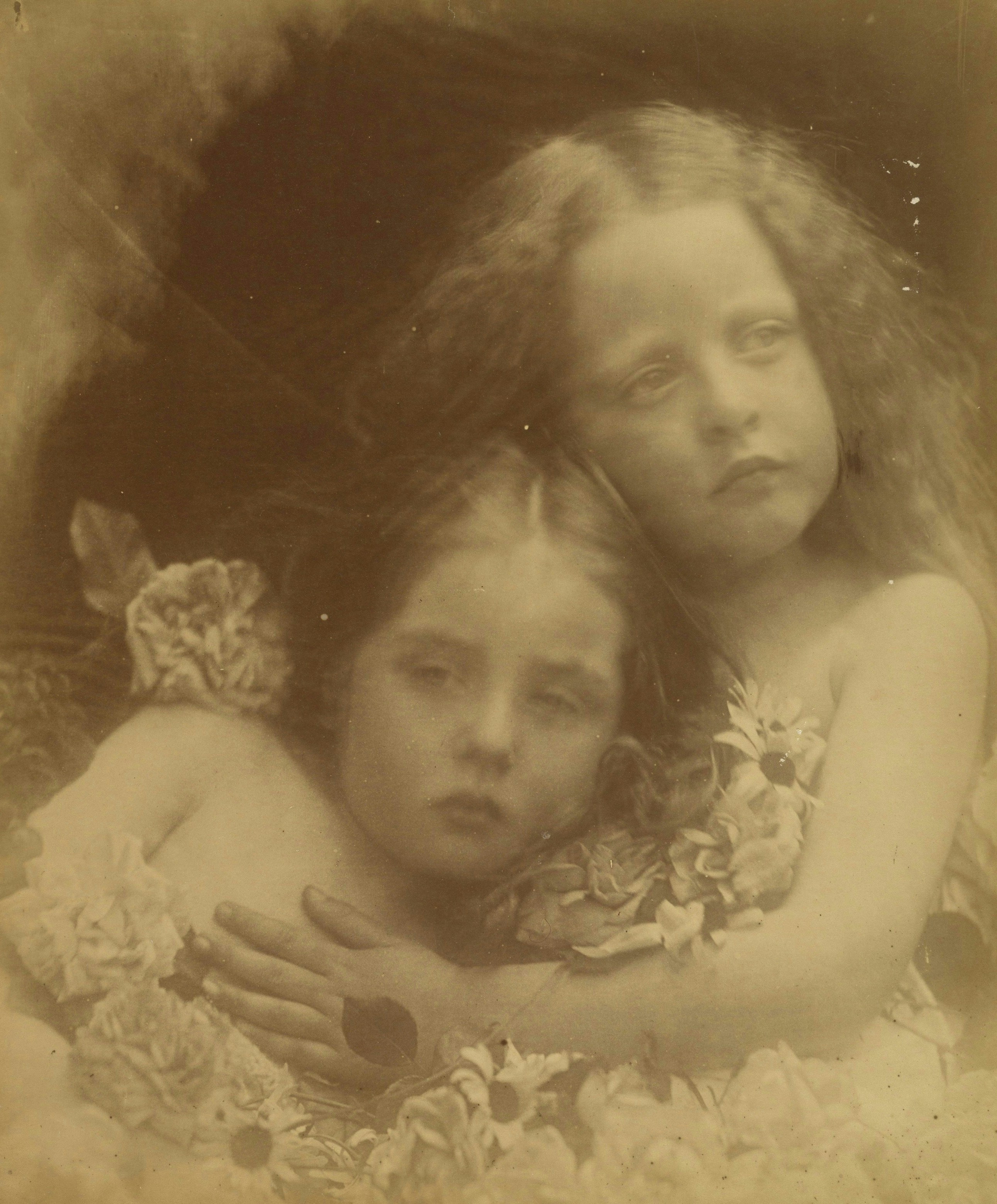 Sepia-toned portrait of two young girls embracing.