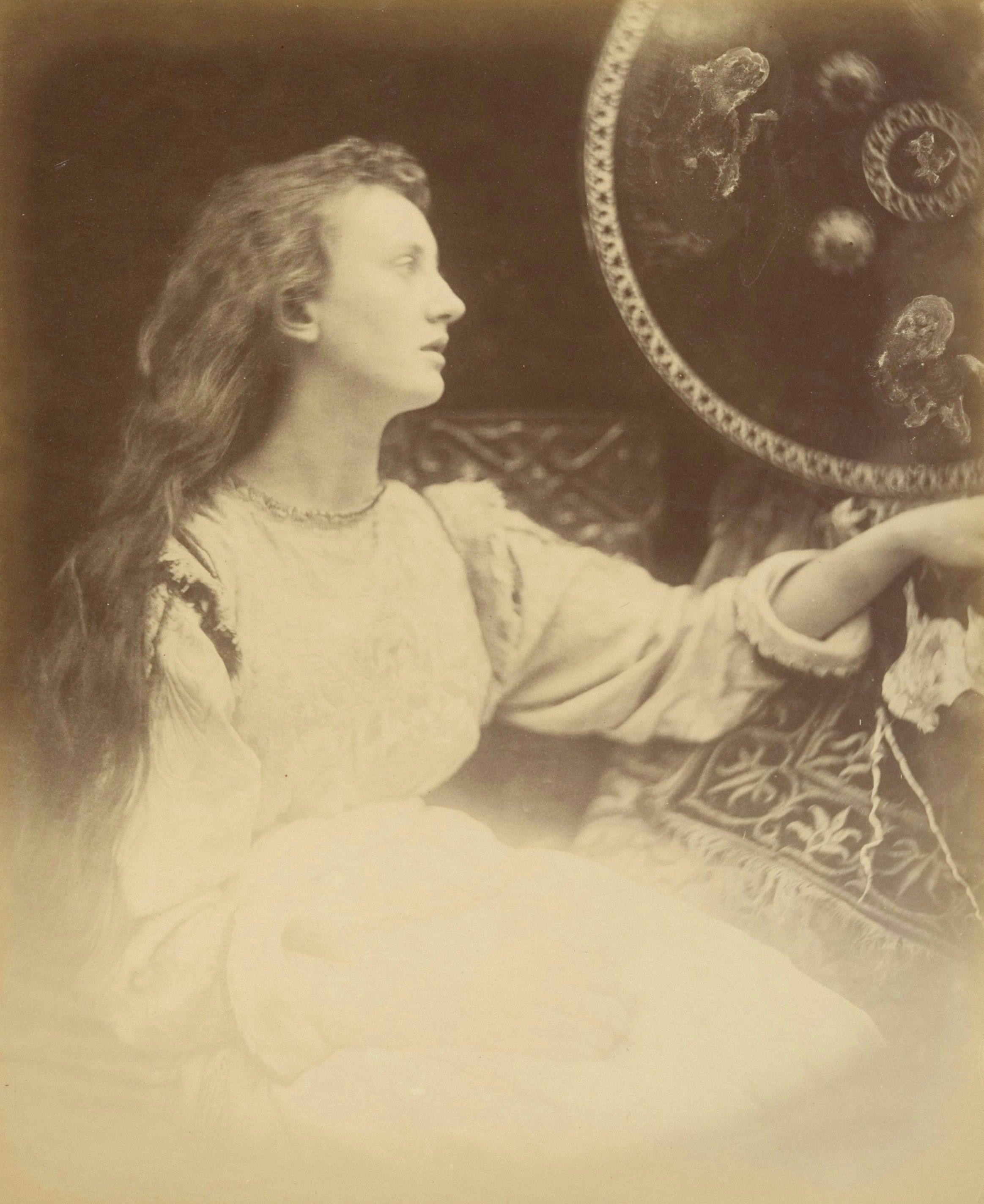 A woman with long hair gazes towards a decorative shield
