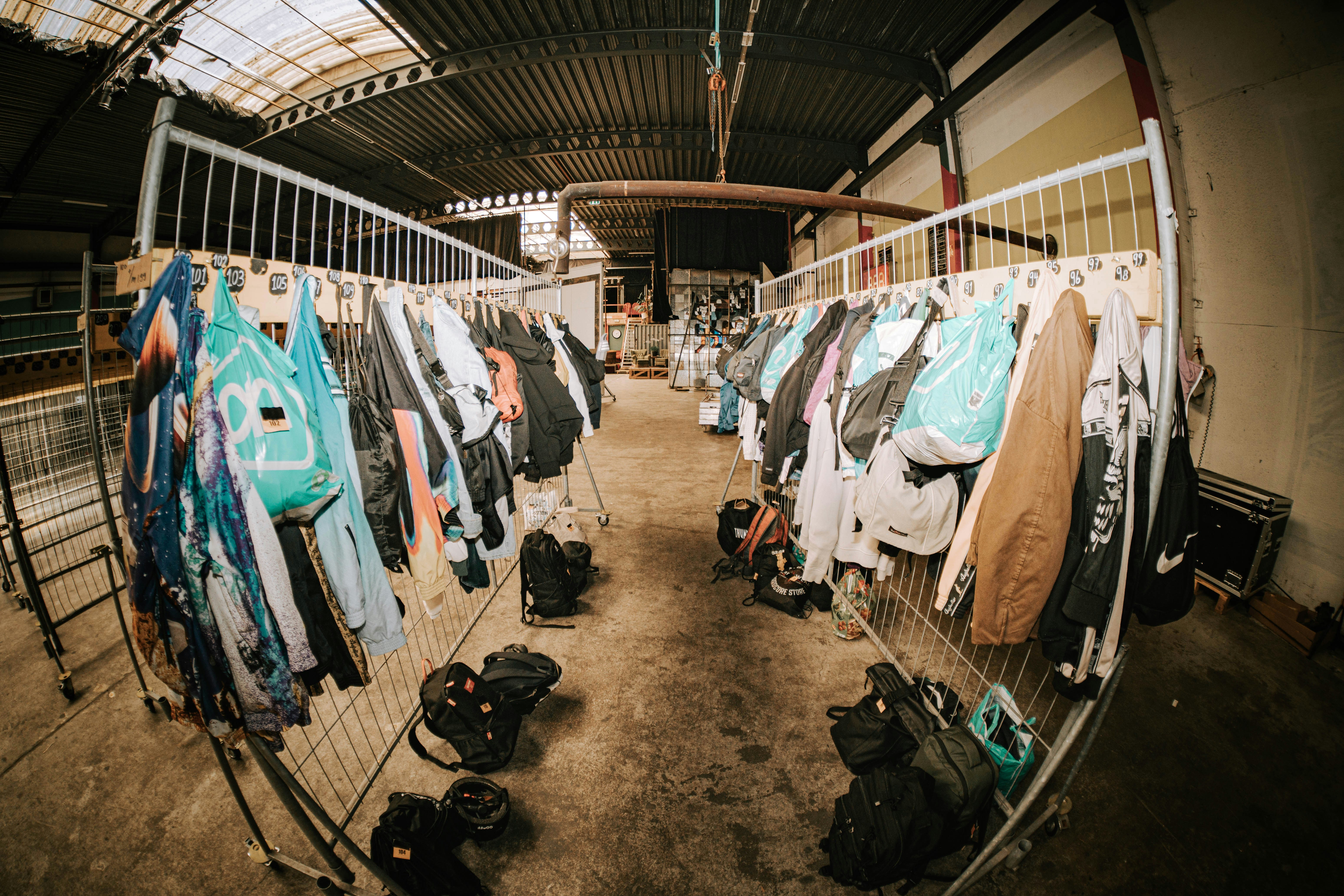 Rows of jackets hanging on racks in an industrial building.