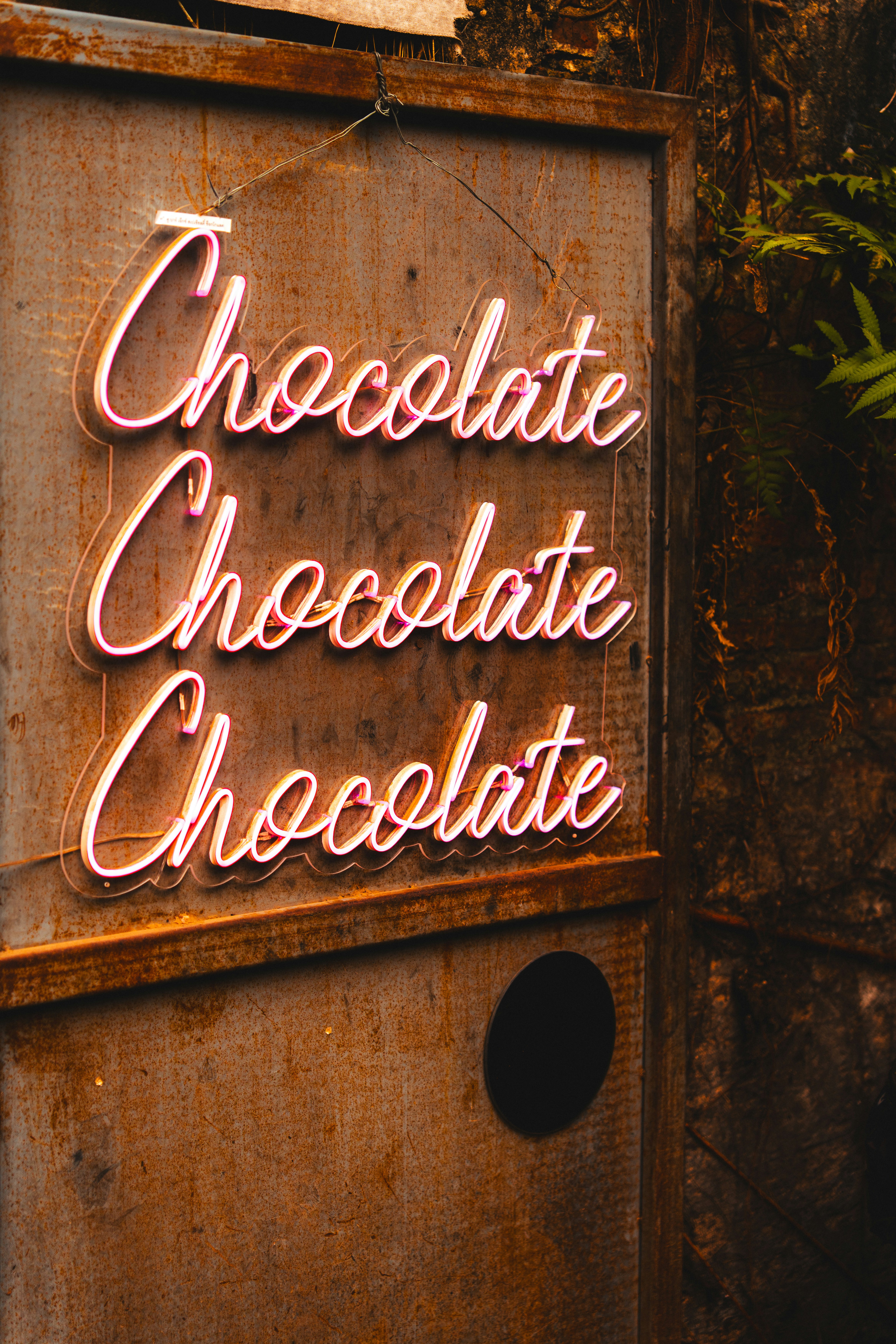 Rustic sign with glowing pink "chocolate" neon letters