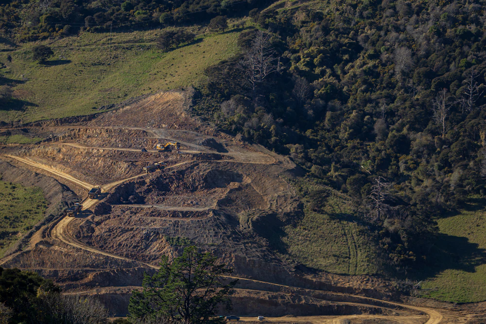Raw, uneven cut ground on a hillside site before finish grading