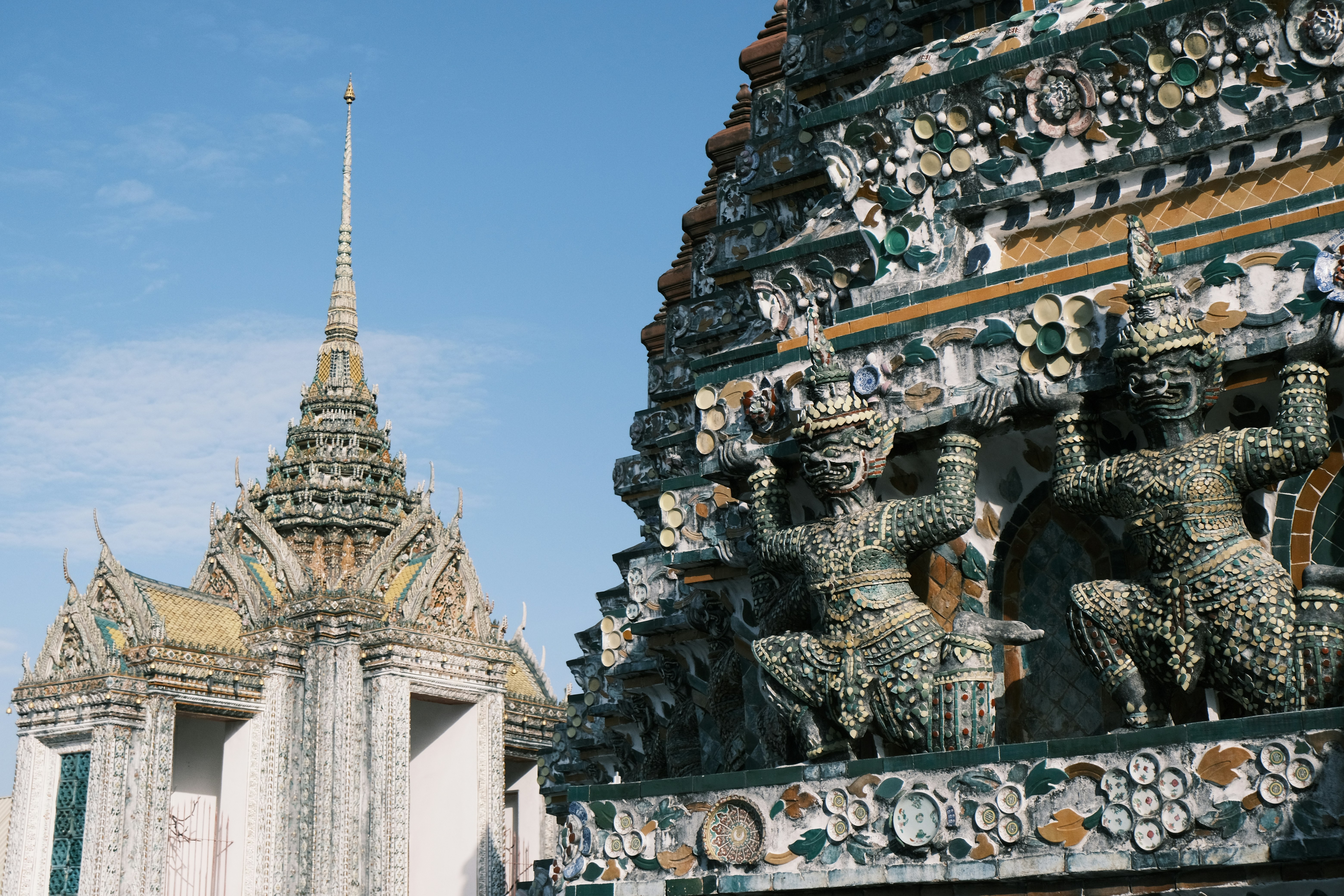 Ornate temple structures with intricate carvings under a blue sky.