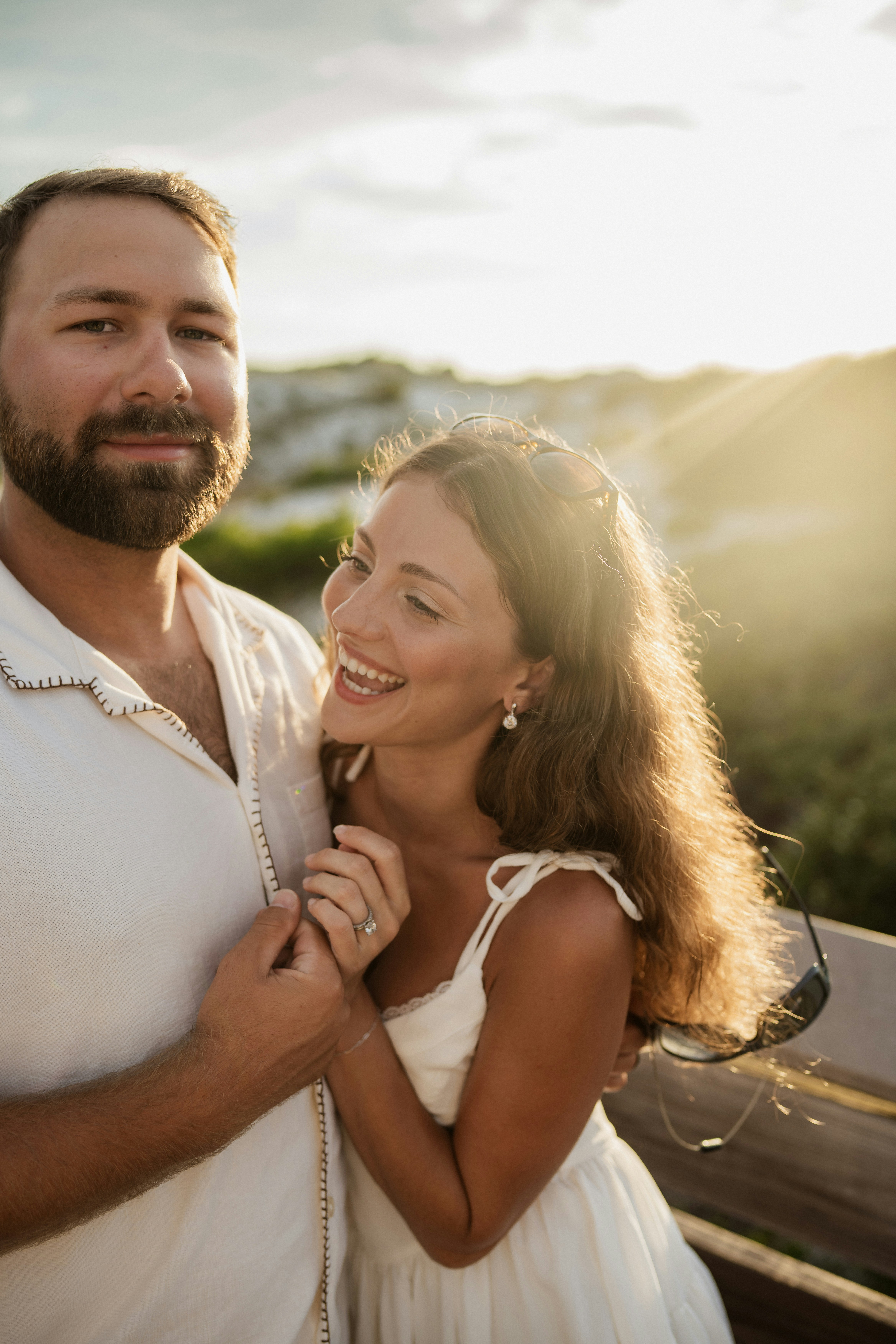 A happy couple embracing outdoors at sunset.