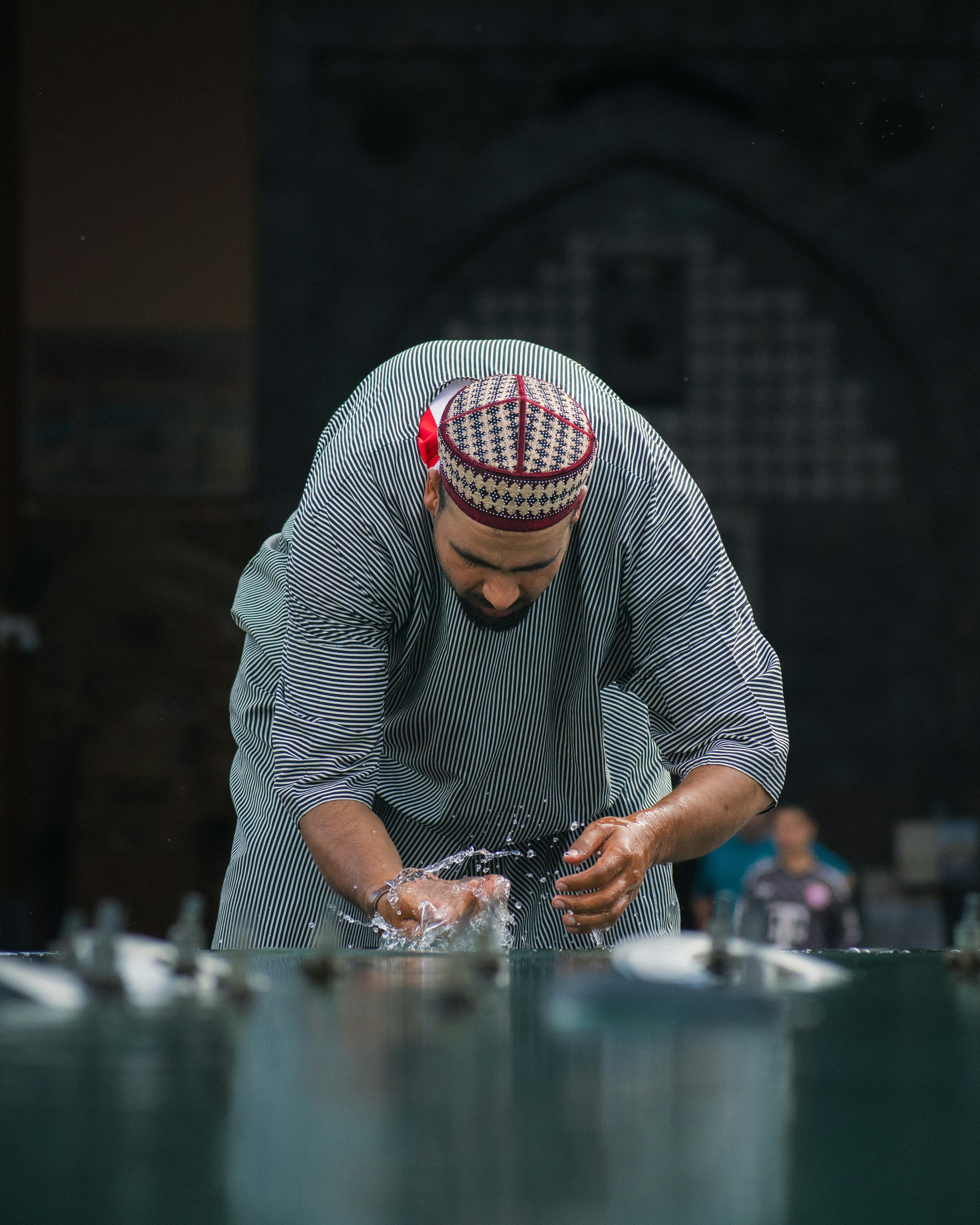 A man performs ritual ablution with splashing water.