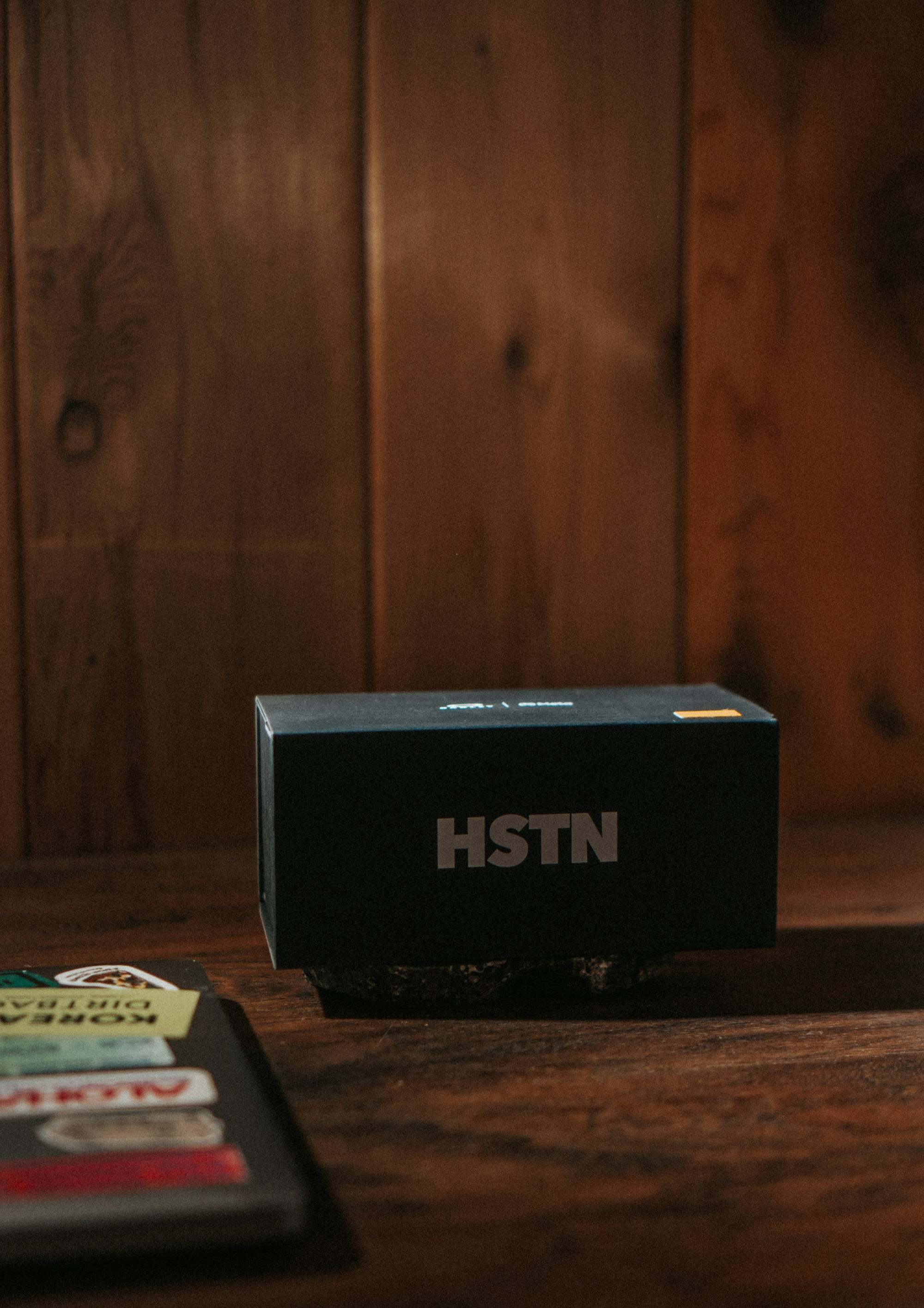 Black hstn box on a dark wooden table.