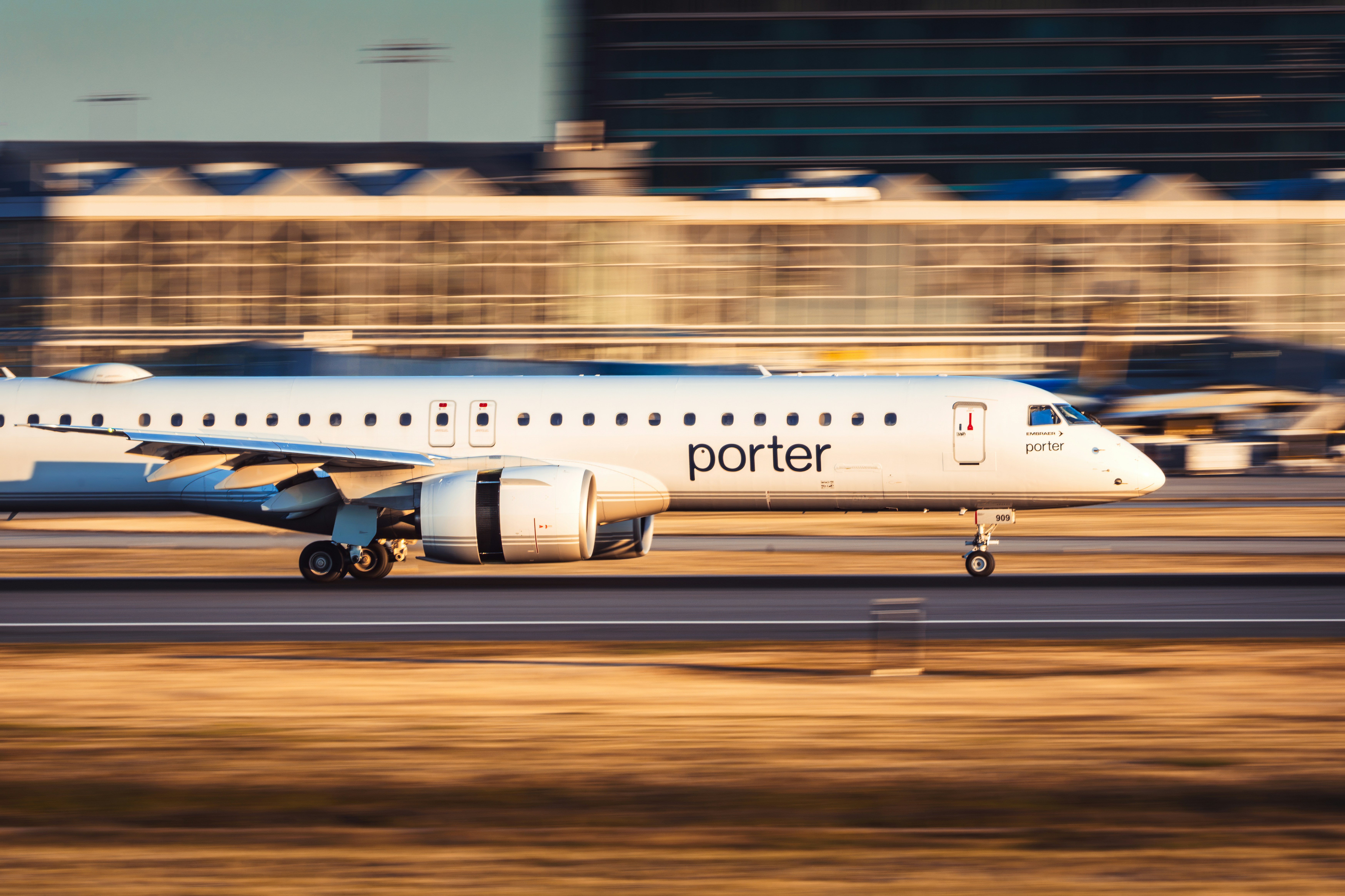 White porter airplane accelerating on a blurred airport runway.