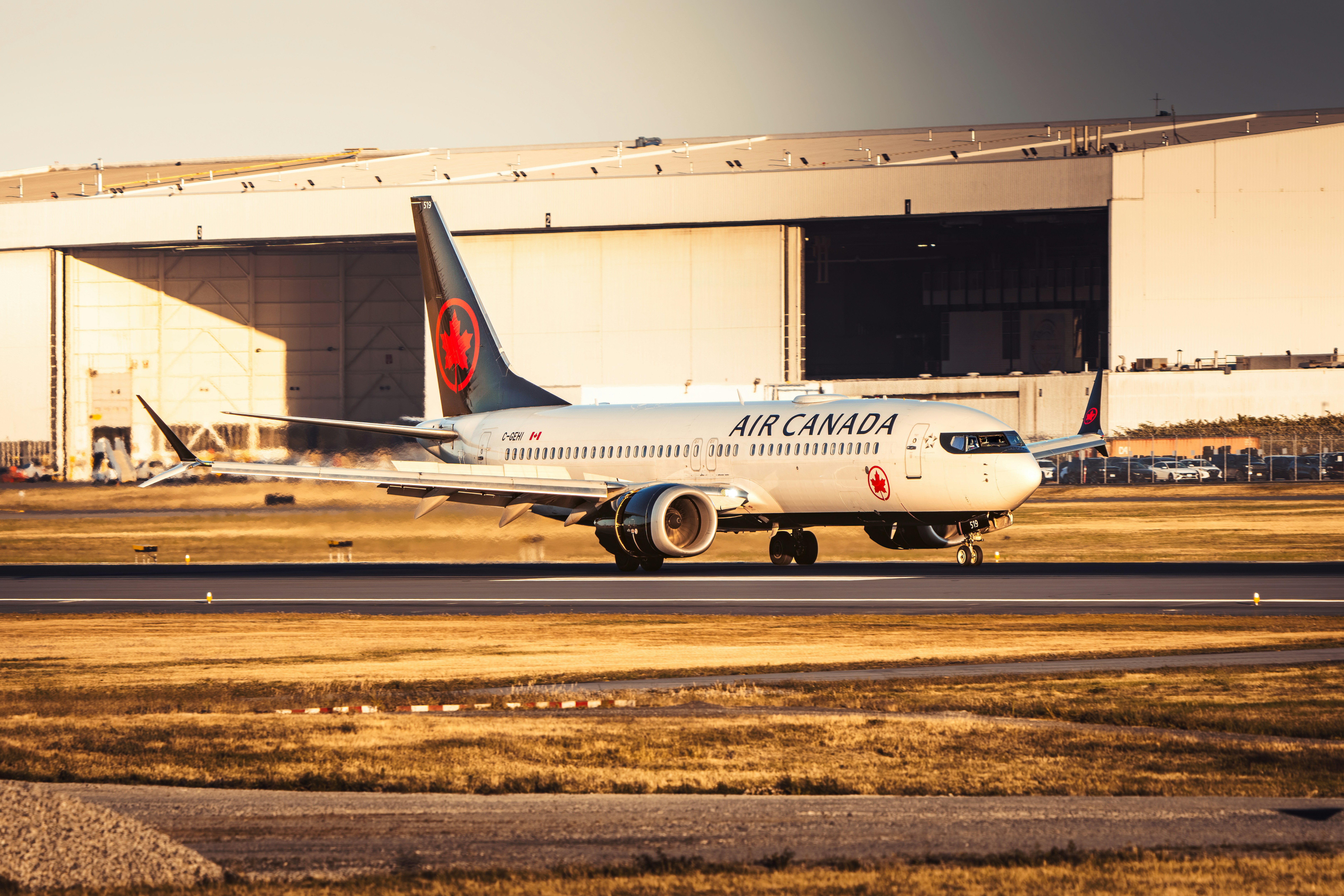 Air canada plane taxiing on an airport runway.