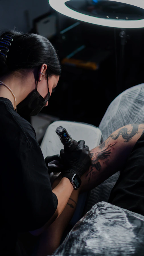 Tattoo artist creating a custom design on client's arm