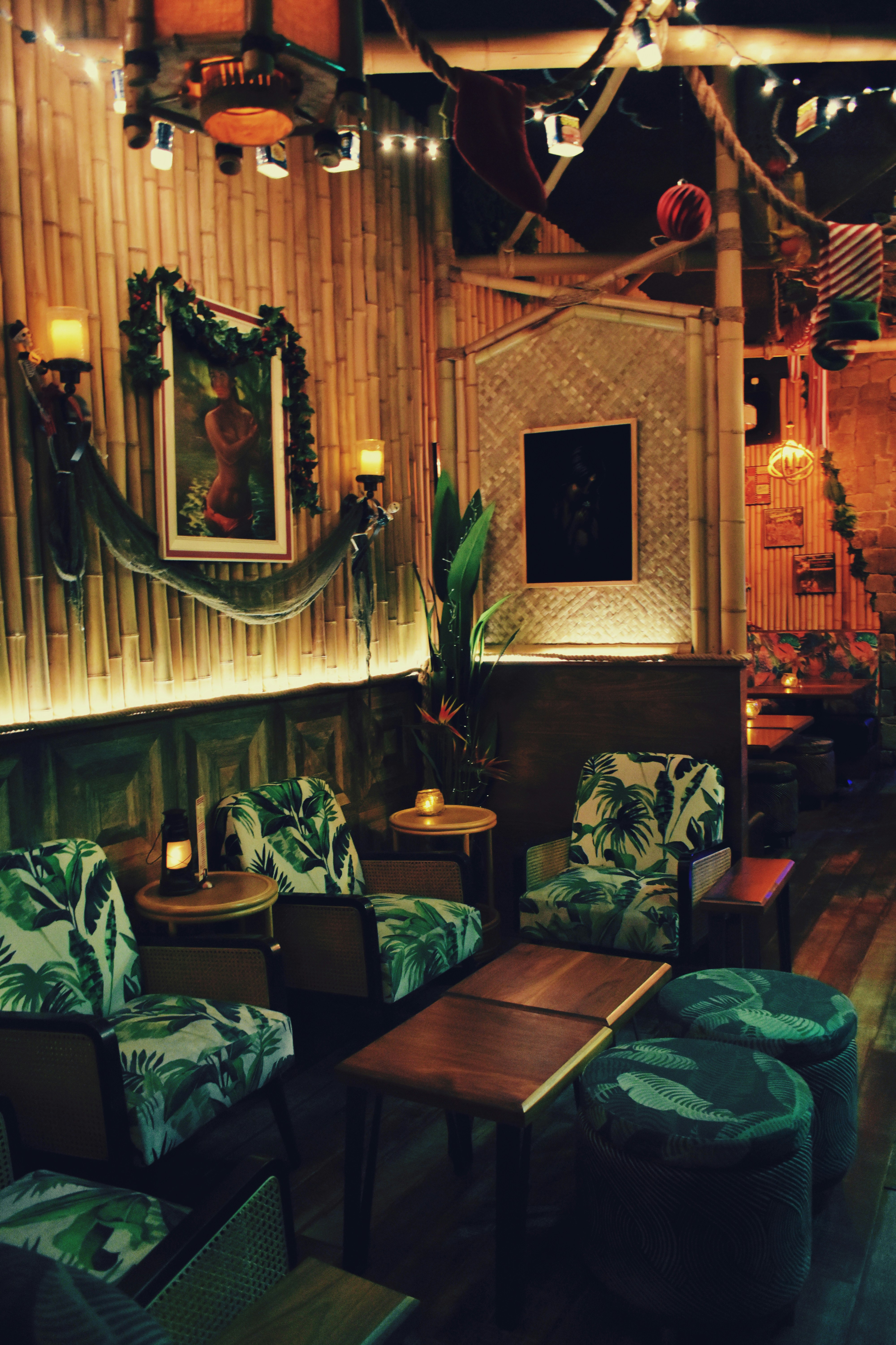 Cozy tiki lounge featuring bamboo decor and tropical patterned seating.