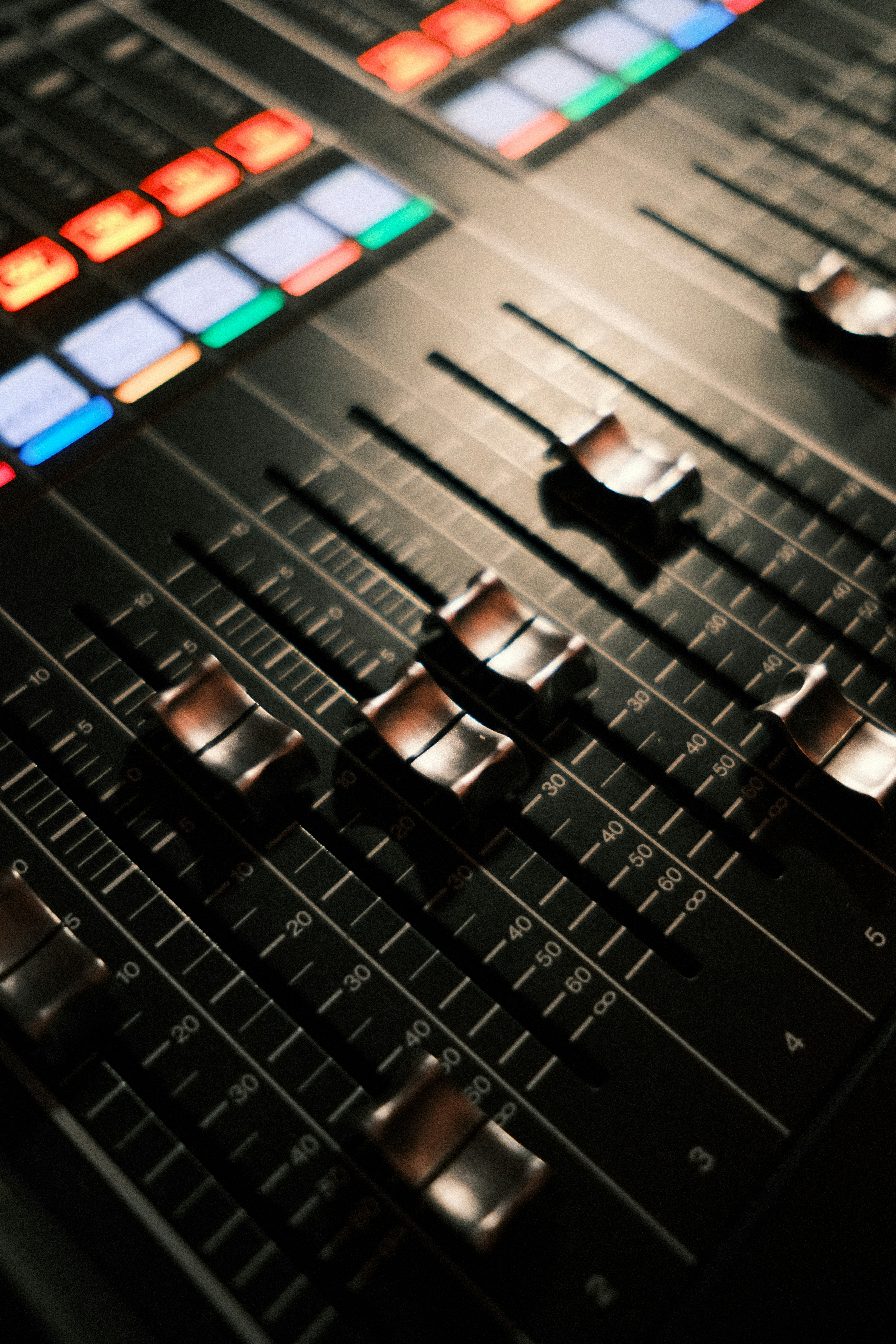 Console de mixage audio avec faders et boutons lumineux